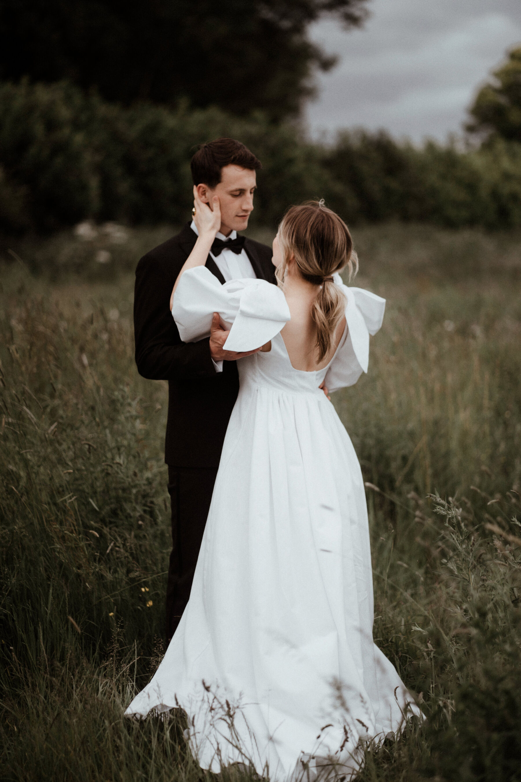 Real bride wearing a Wilden London wedding dress with oversized bows on the shoulders. Image by Rebecca Rees Photography.