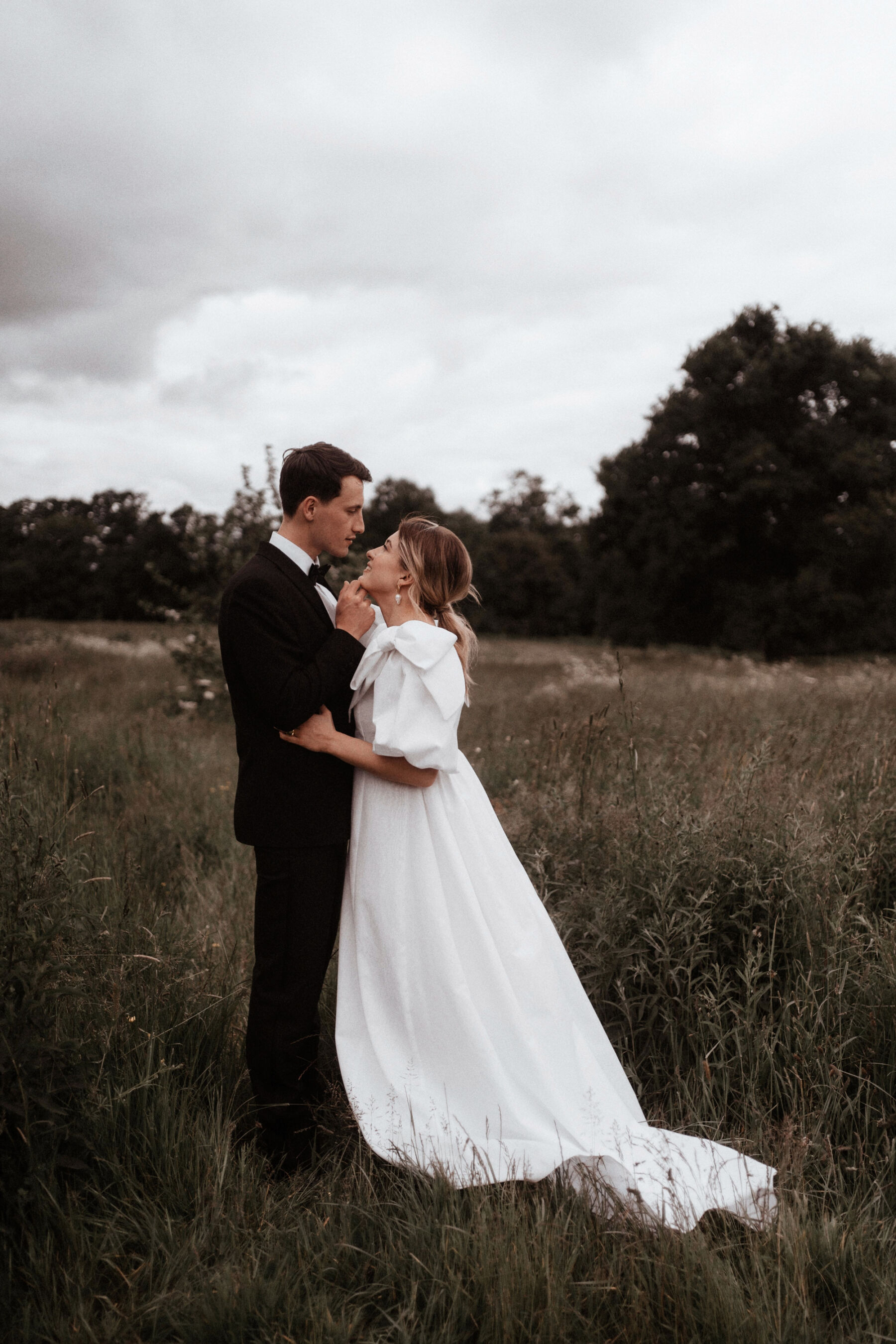 Real bride wearing a Wilden London wedding dress with oversized bows on the shoulders. Image by Rebecca Rees Photography.