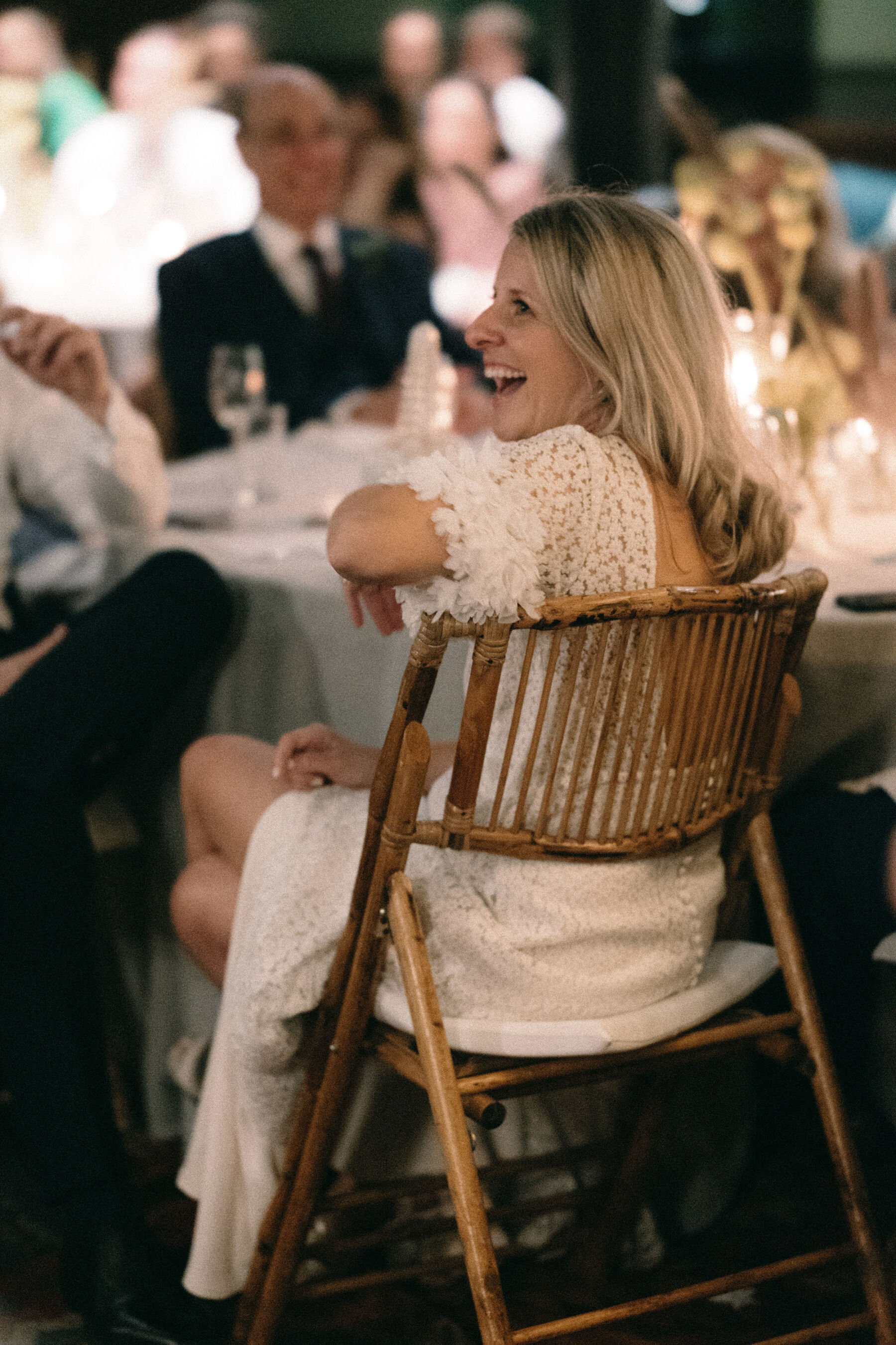 Bride sat in a wicker chair, wearing Immacle wedding dress. Rebecca Rees Photography.