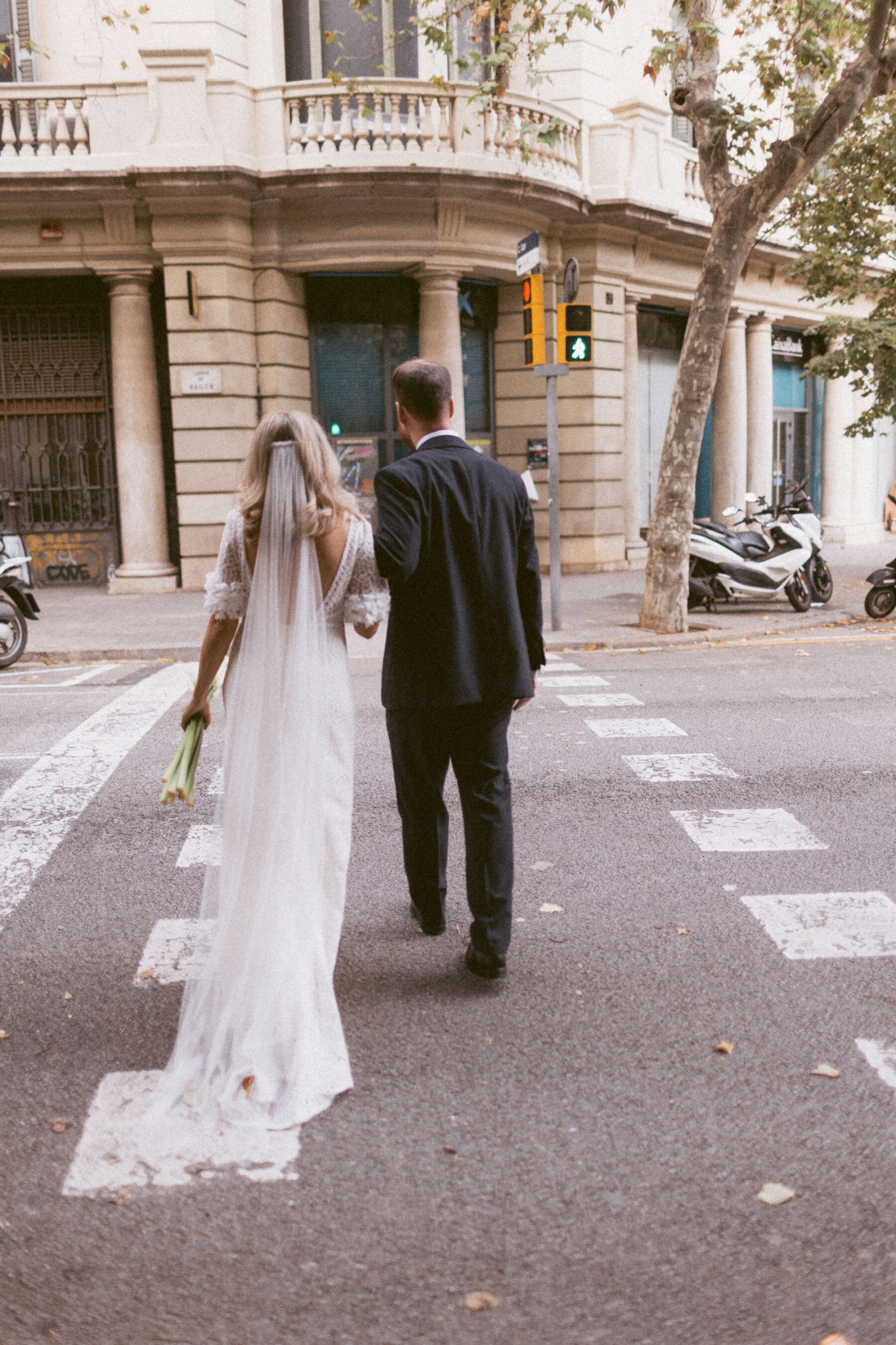 Bride and groom crossing the street in Barcelona.  Rebecca Rees Photography.