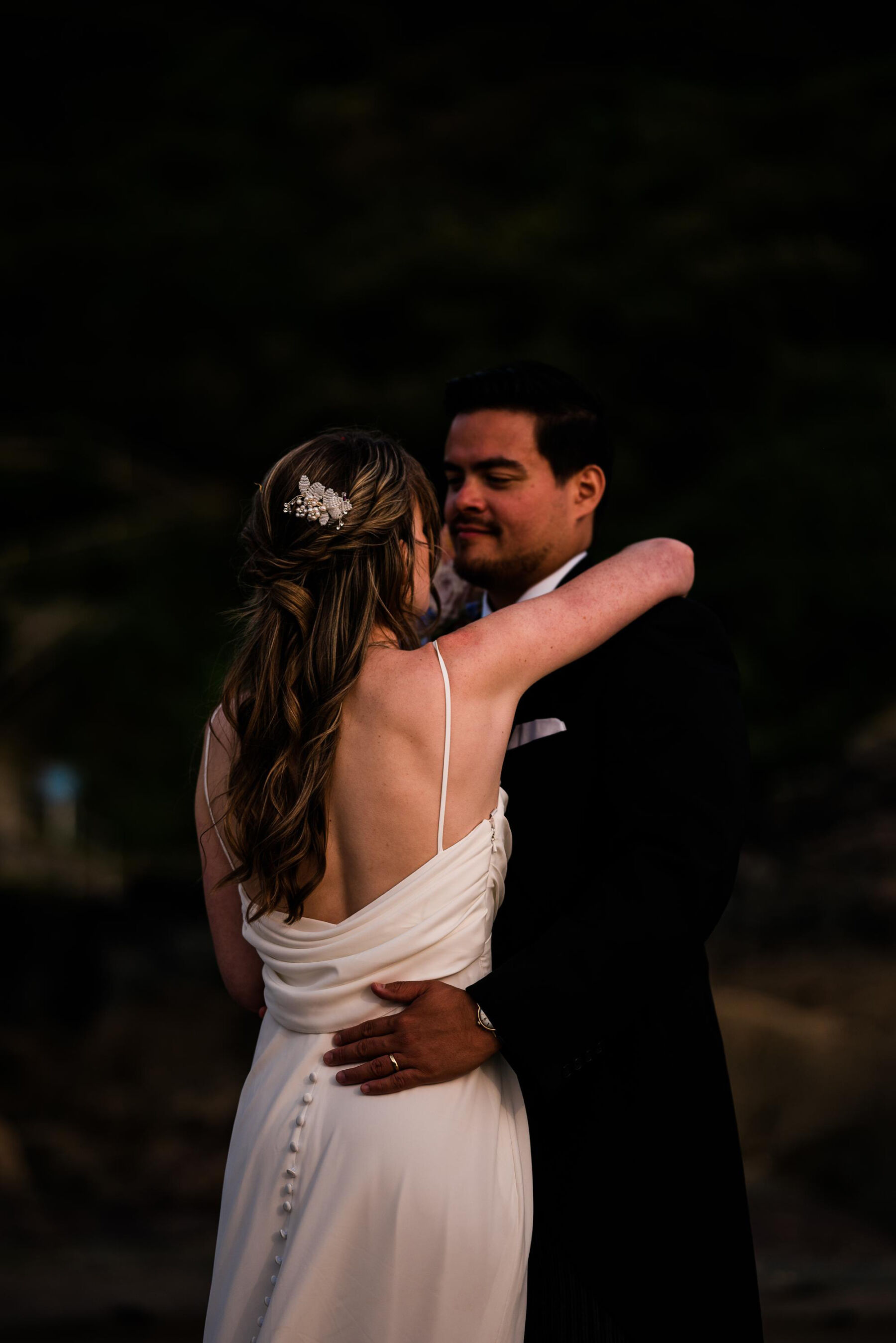 Bride and groom embracing in the early evening