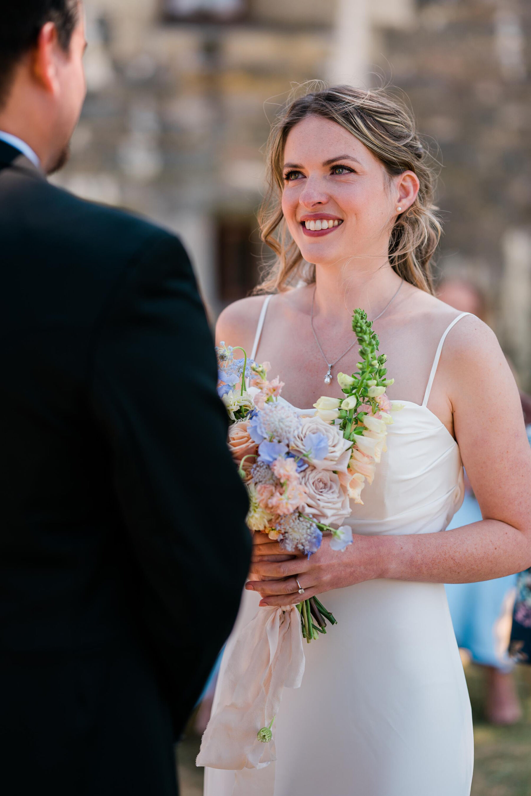 Bride looking lovingly into her groom's eyes during outdoor ceremony