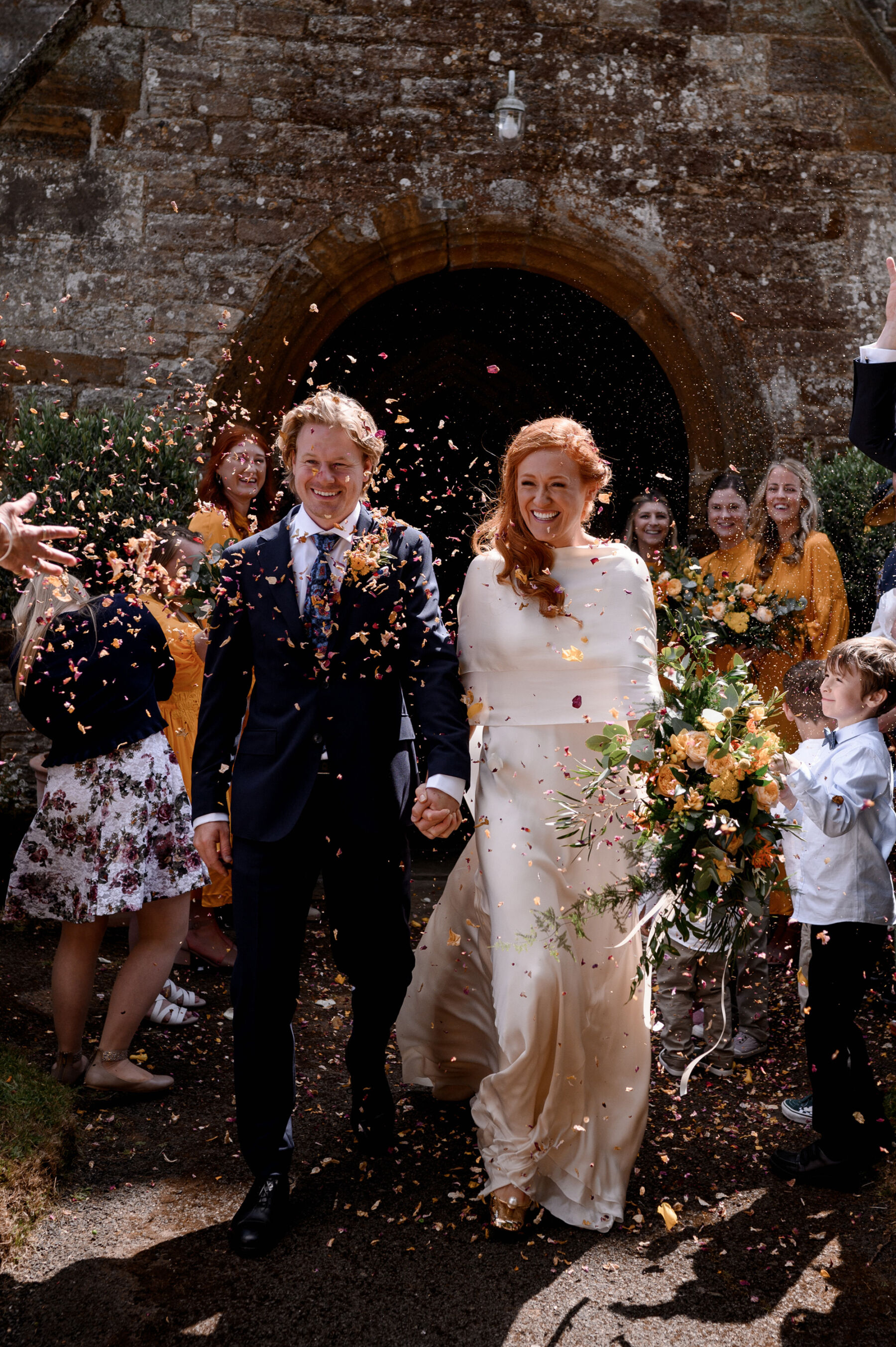 Confetti shot of red haired bride wearing a Cortana gown from The Fall Bride, London. Taylor Hughes Photography.
