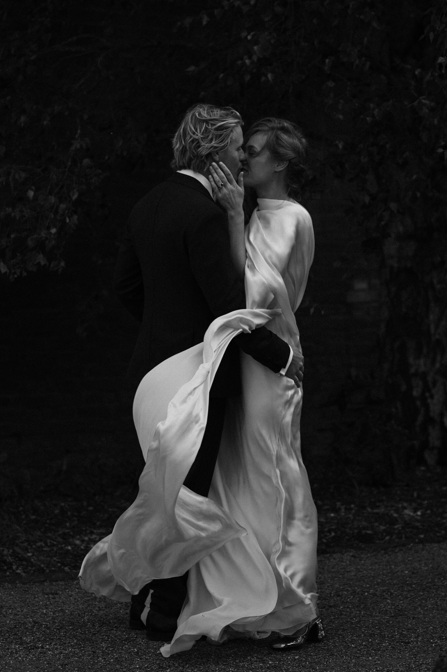 Black and white shot of bride wearing Cortana gown kissing her groom. Taylor Hughes Photography.