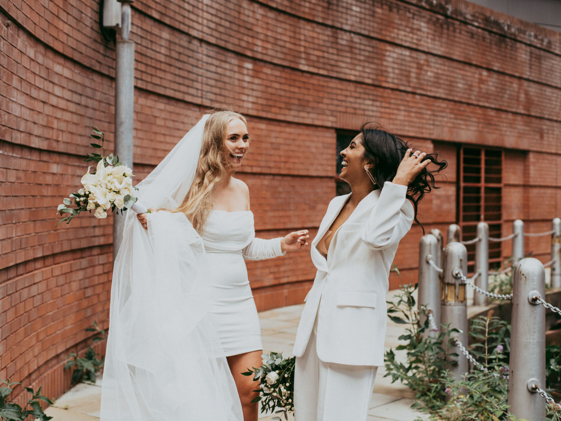 Same sex wedding. Lesbian bride in short dress. Lesbian bride in suit.  Daniel Mice Photography.