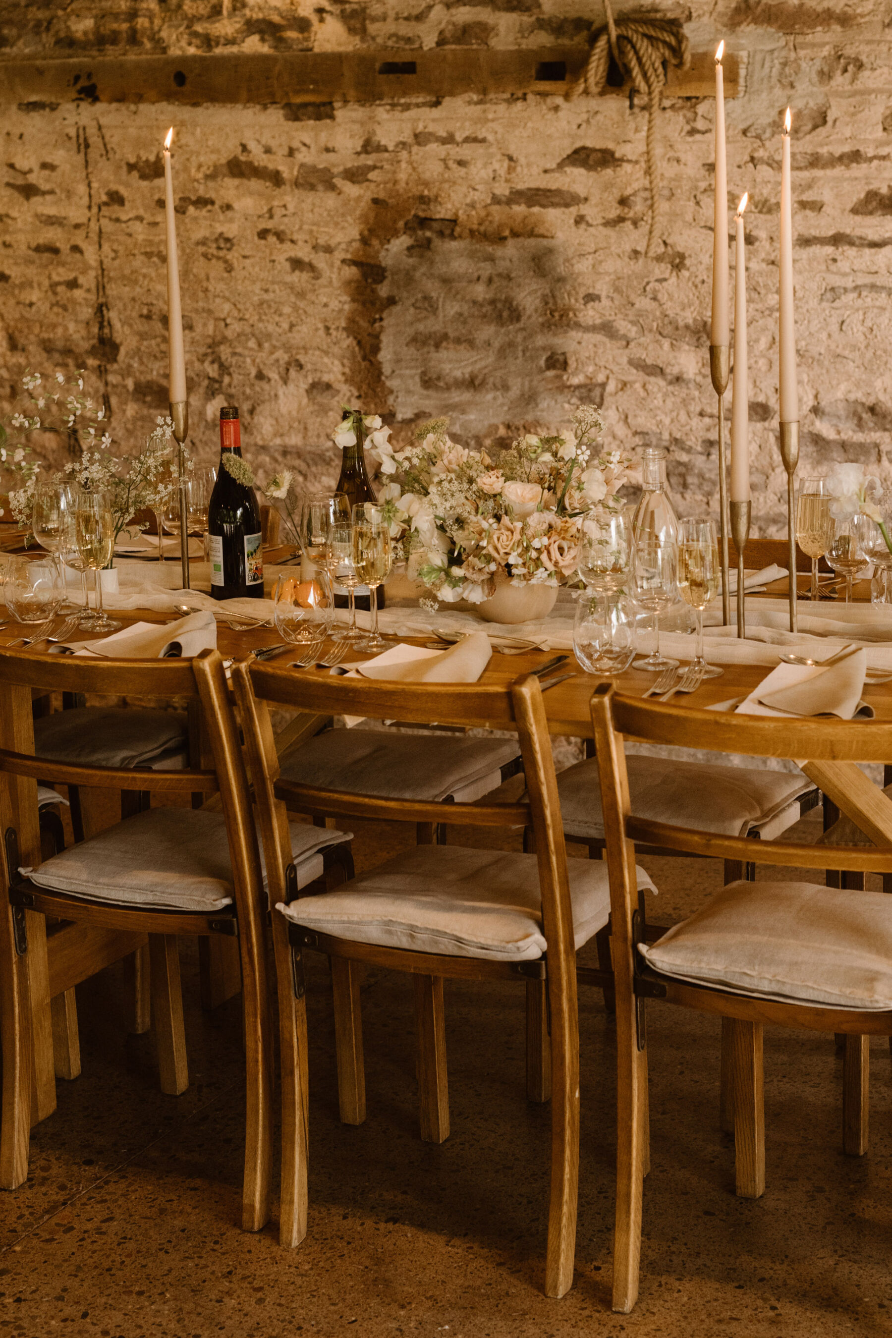 A Look Inside Dewsall Court Country House, A Family Run Wedding Venue in Herefordshire 31 Wedding reception at Dewsall Court. Long wooden trestle tables with tall pink taper candles and pastel flowers. Agnes Black Photography.