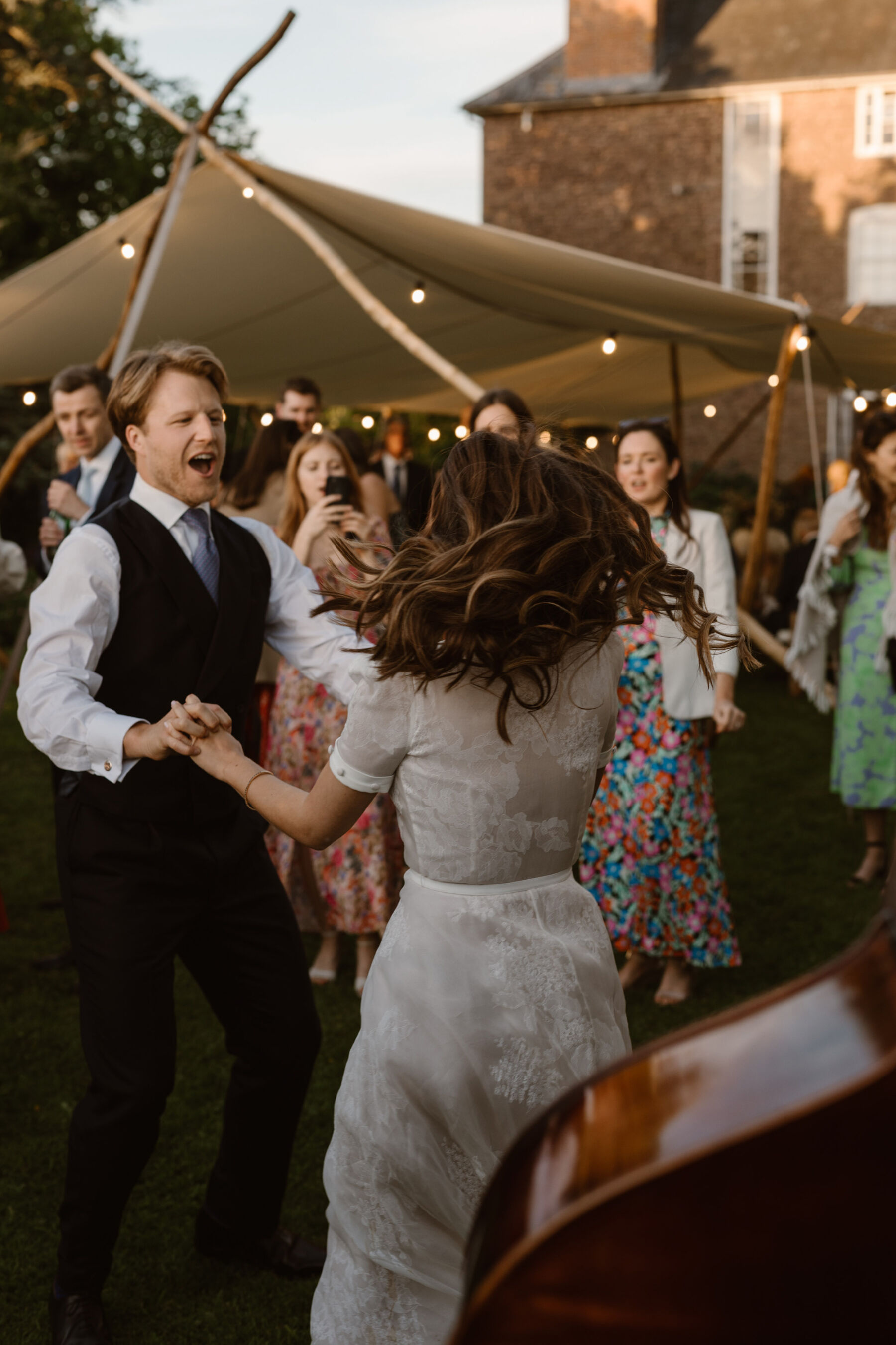 Bride and groom spinning around during their first dance outdoors at Dewsall House. Bride in short sequin dress on the dance floor. Agnes Black Photography.