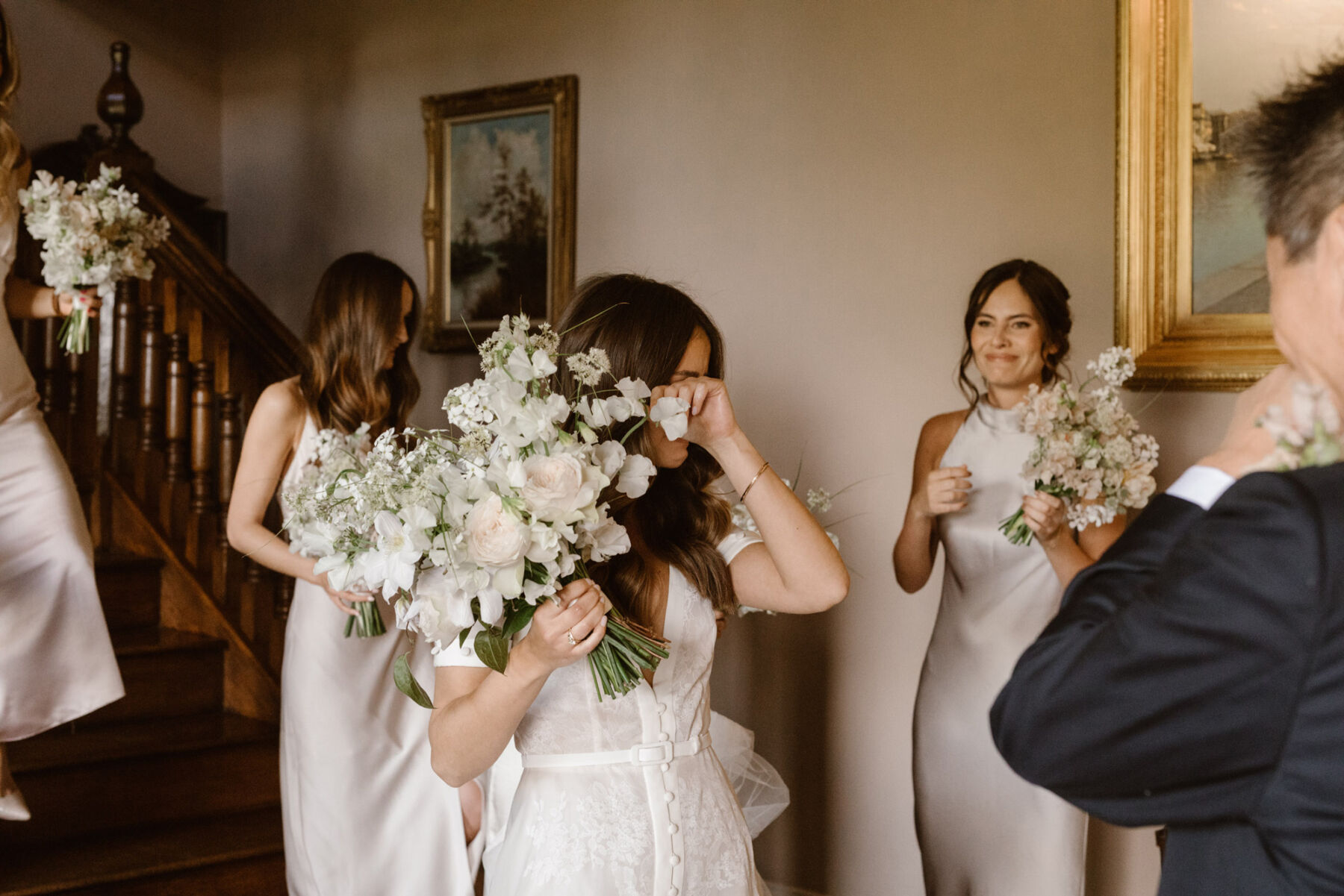 Bride wiping away tears - holding a white and pale pink bridal bouquet. Agnes Black Photography.