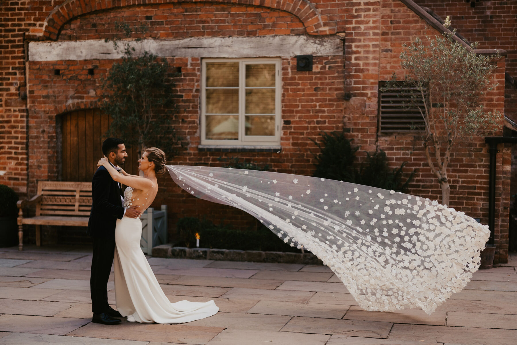 Long wedding veil covered in cut-out silk fabric flowers. Shustoke Barn wedding venue.