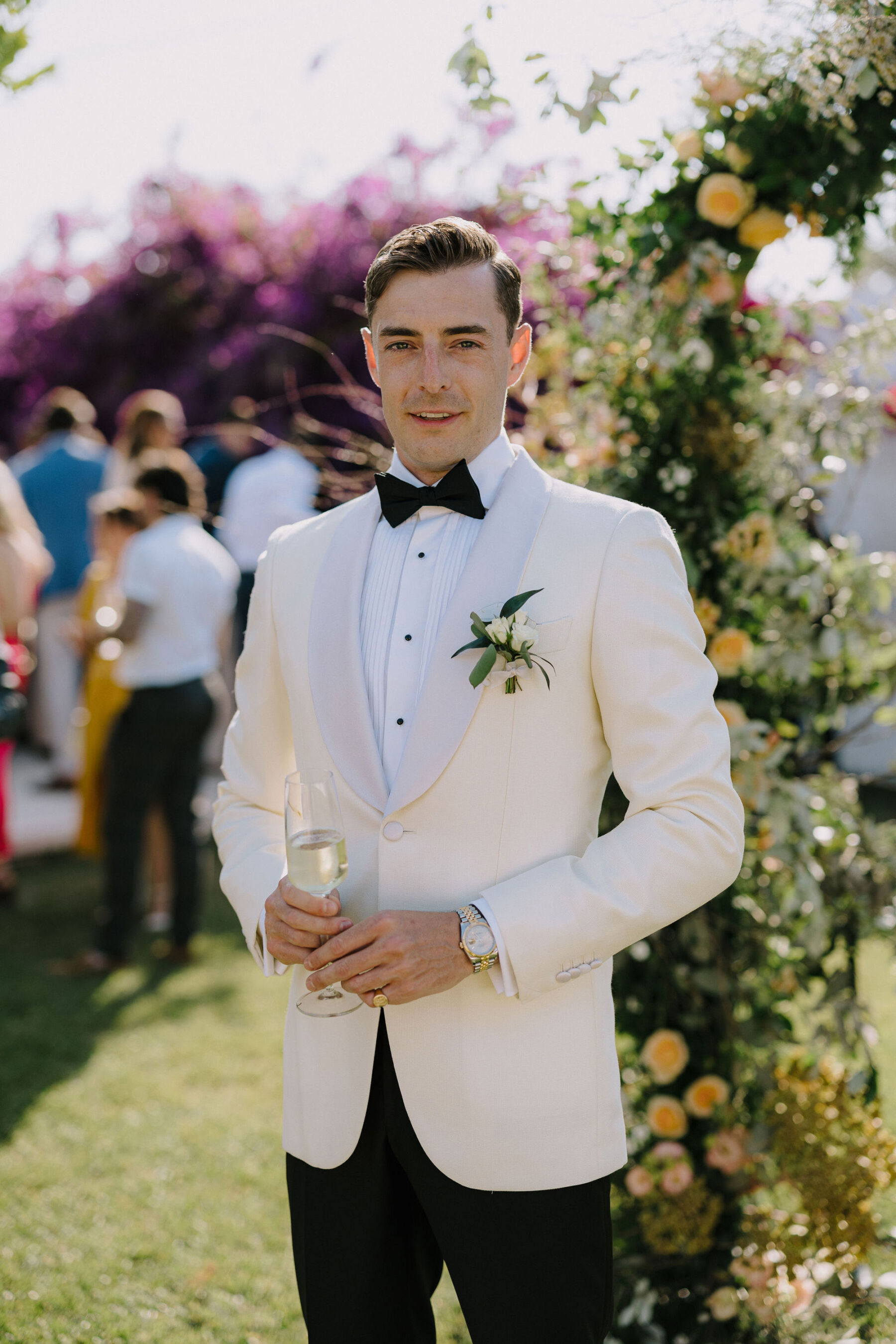 Groom in white tuxedo by Suit Supply.