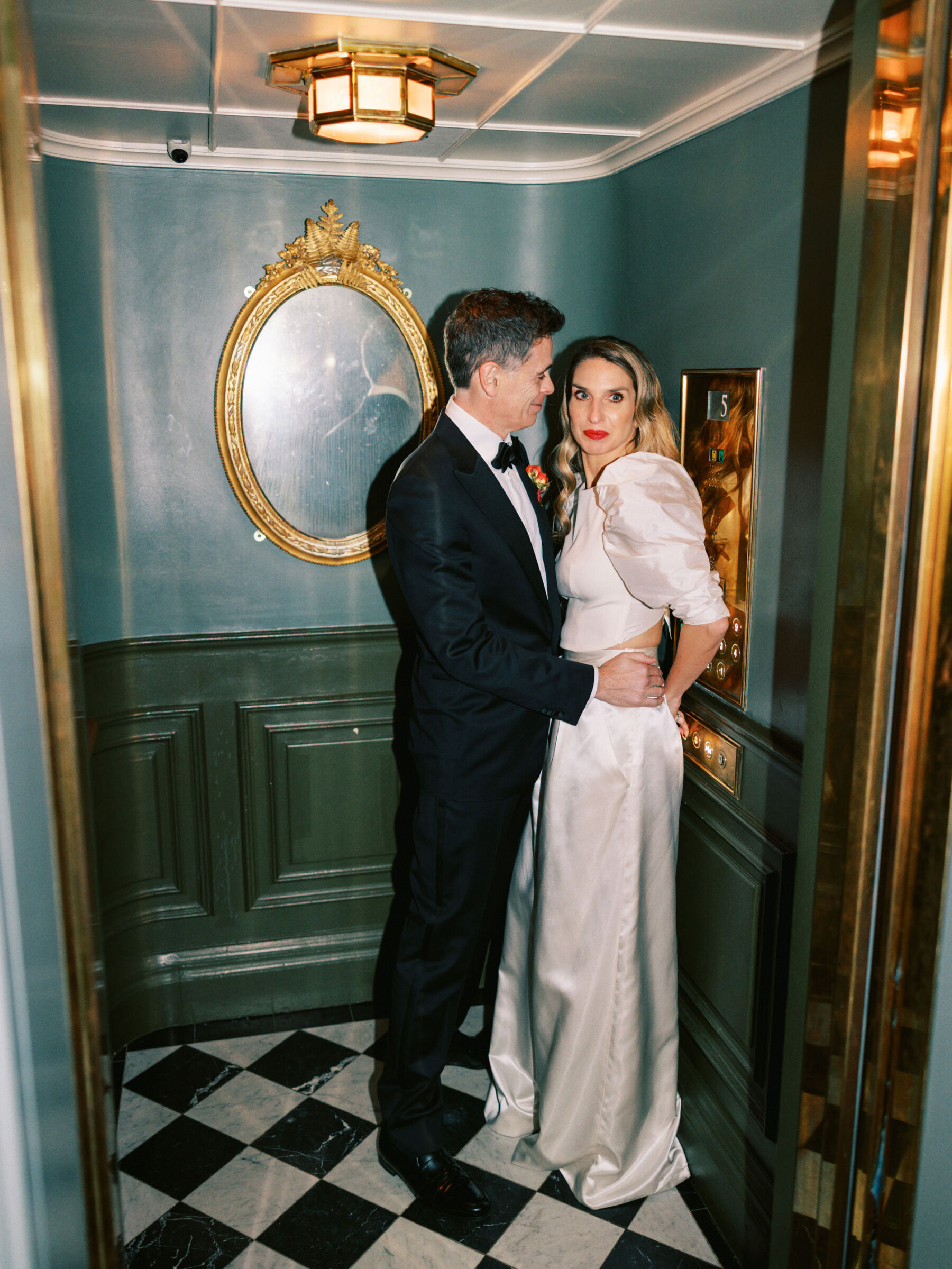 Glamorous bride in red lipstick and wide leg Halfpenny London trousers at The Ned, London. Kernwell Photography.