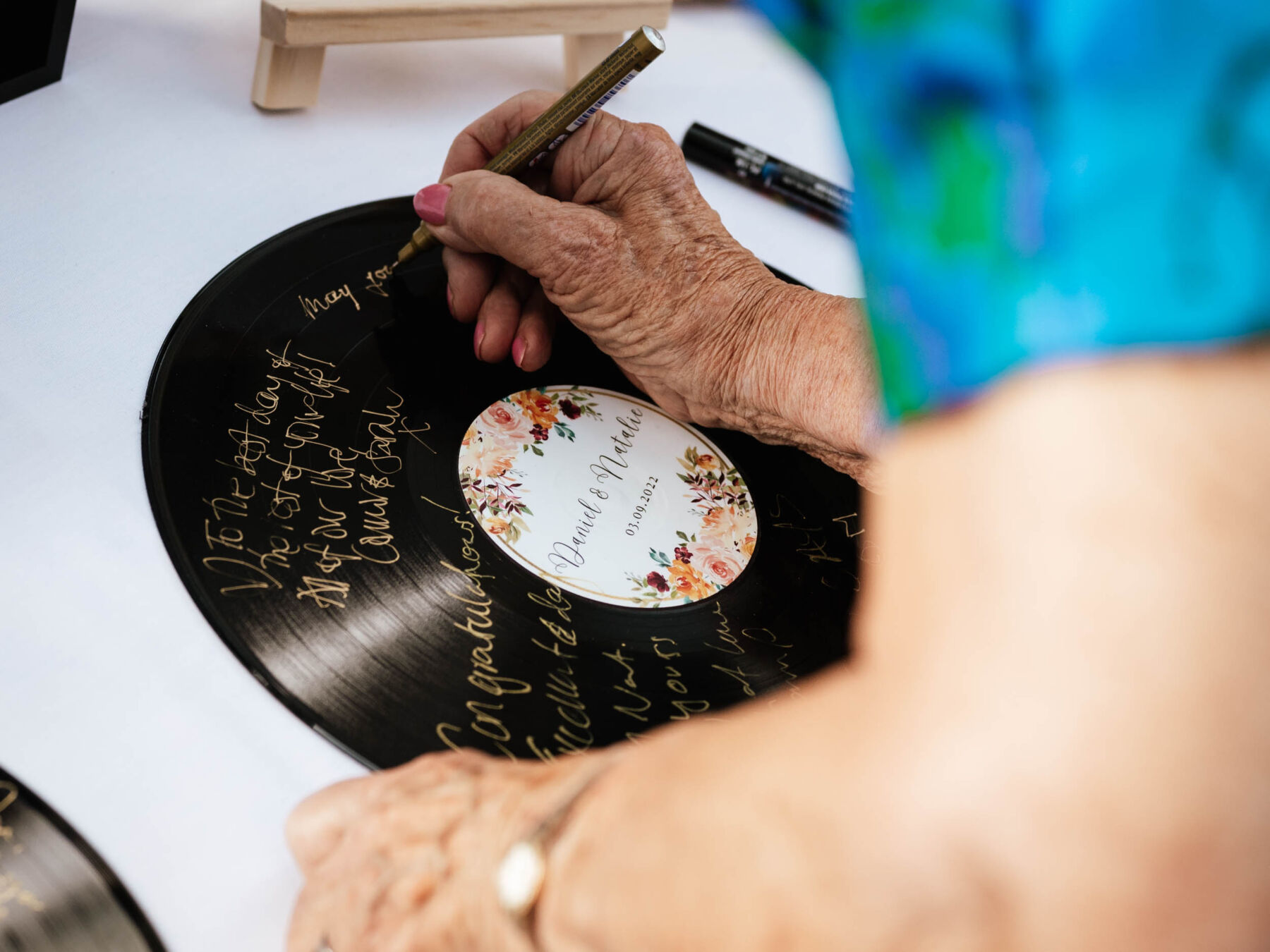 Wedding guest signing a vinyl record - wedding guest book alternative. Robin Goodlad Photography.