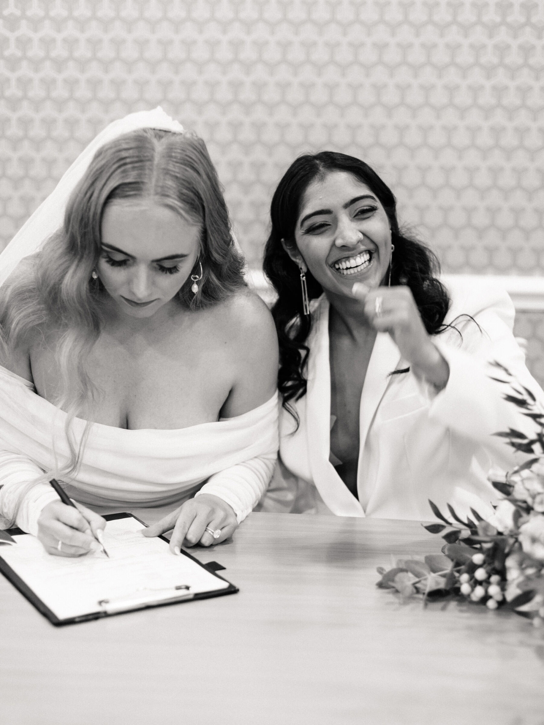 Lesbians signing the register at their wedding at Manchester Registry Office. Daniel Mice Photography.