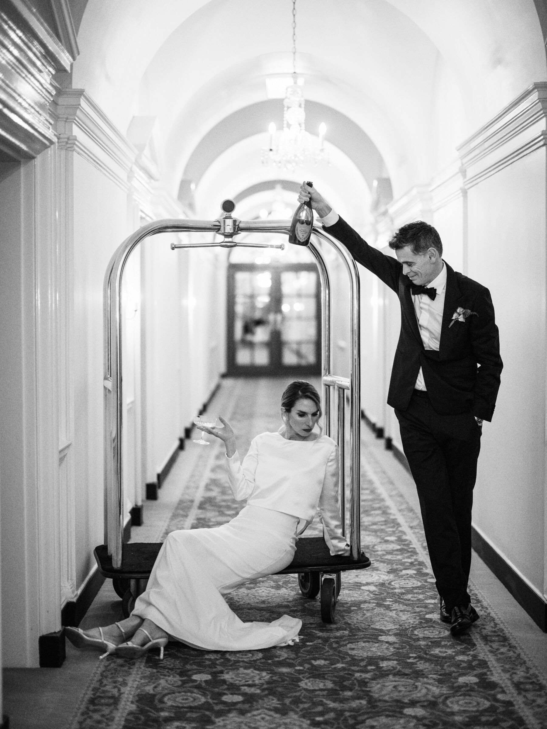 Bride and groom playing on the porters trolley at The Ned, London. Kernwell Photography.