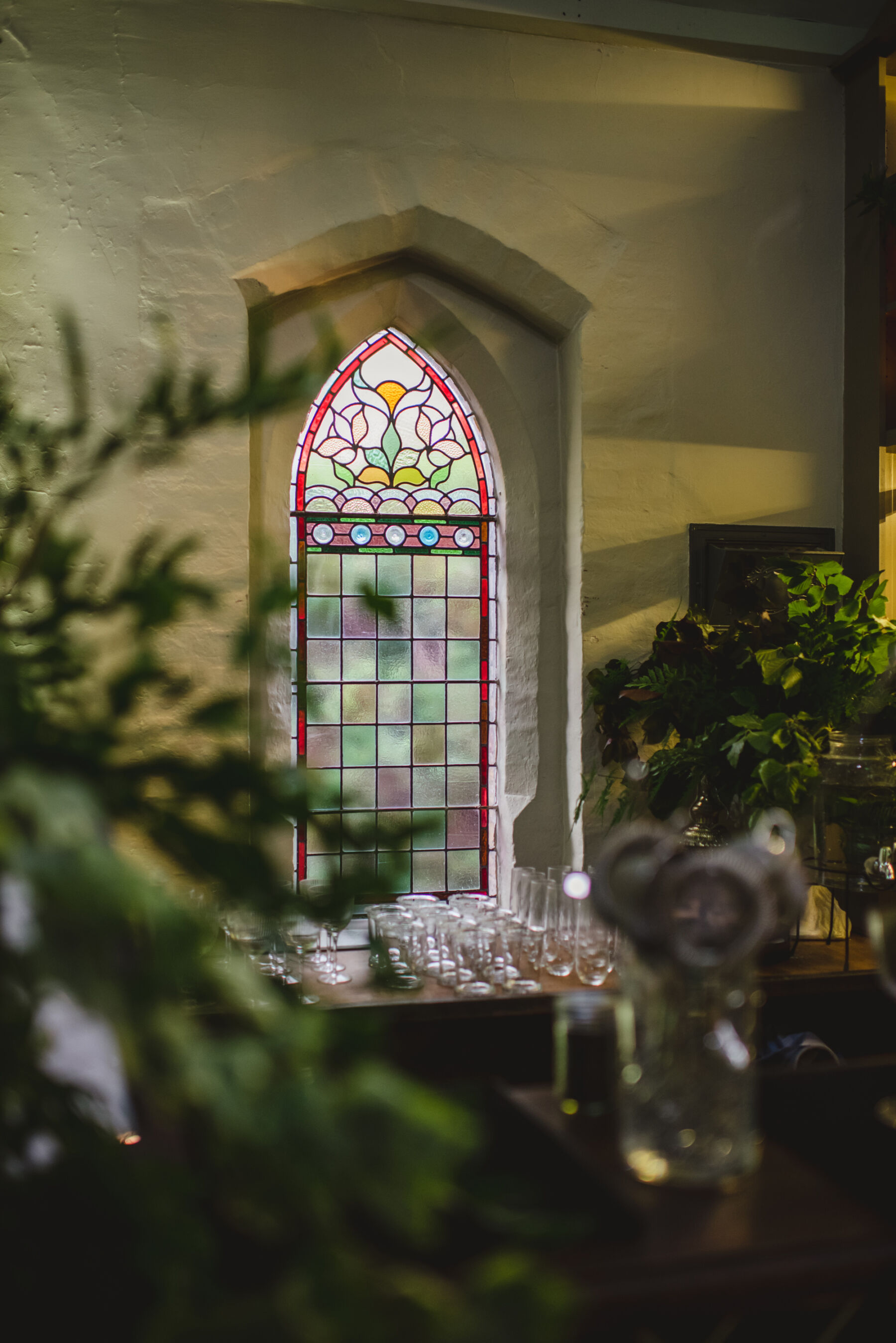 Stained glass window inside Miss Bush - luxury bridal boutique in a former chapel, Ripley, Surrey, UK. Photography by Sophie Duckworth.