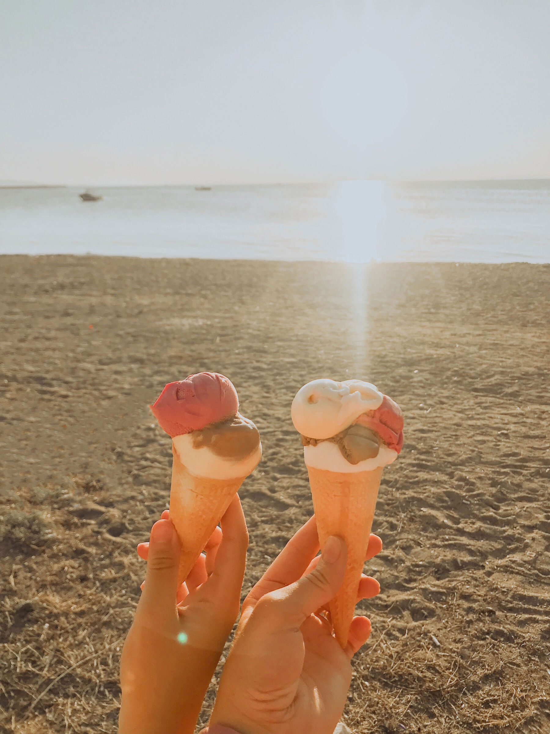 Patchwork alternative wedding gift registry - two icecream cones being held up in the sunshine on the beach.