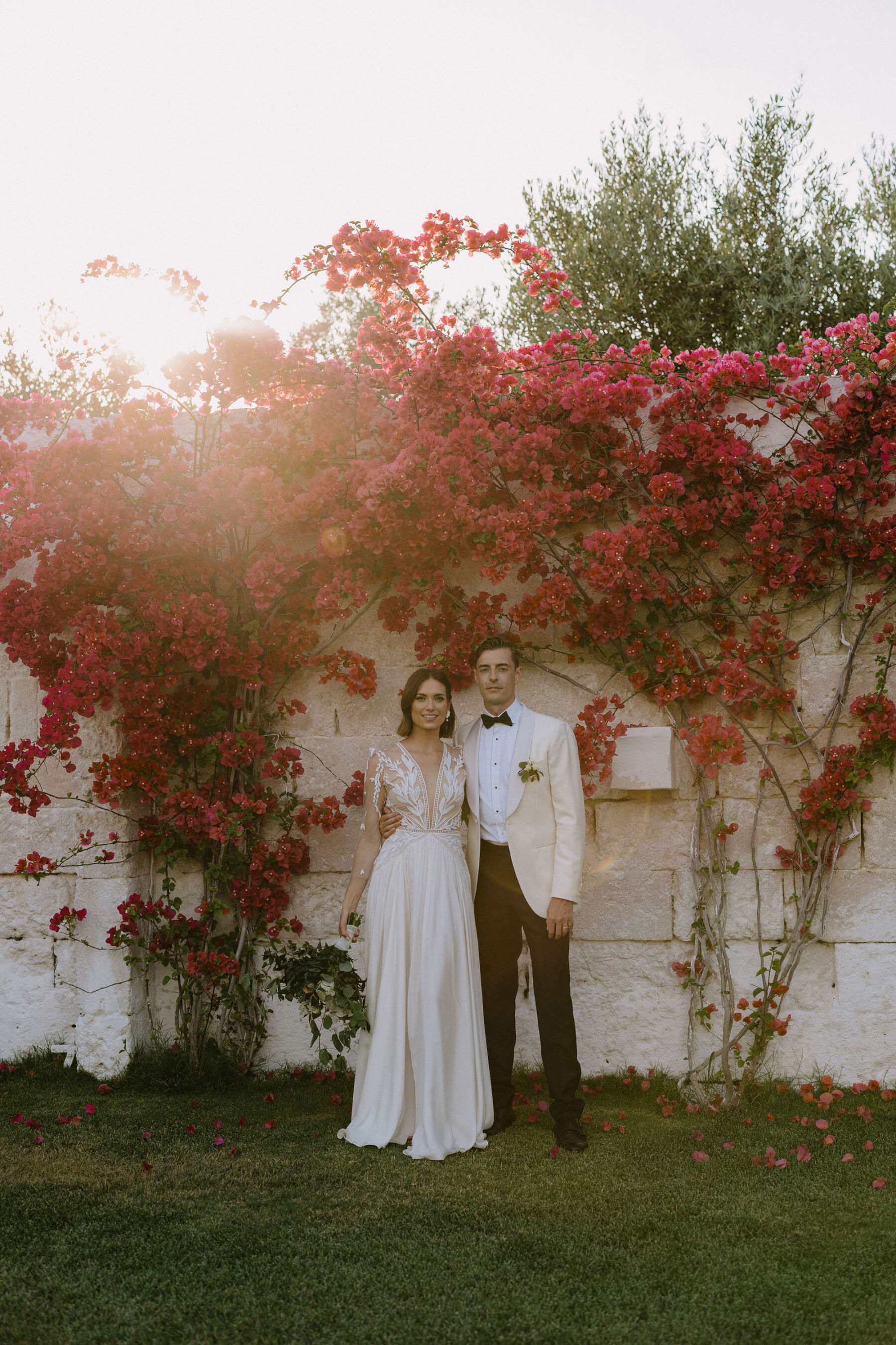 Bride in Margaux Tardits wedding dress. Groom in white tuxedo and black tie. Puglia wedding.