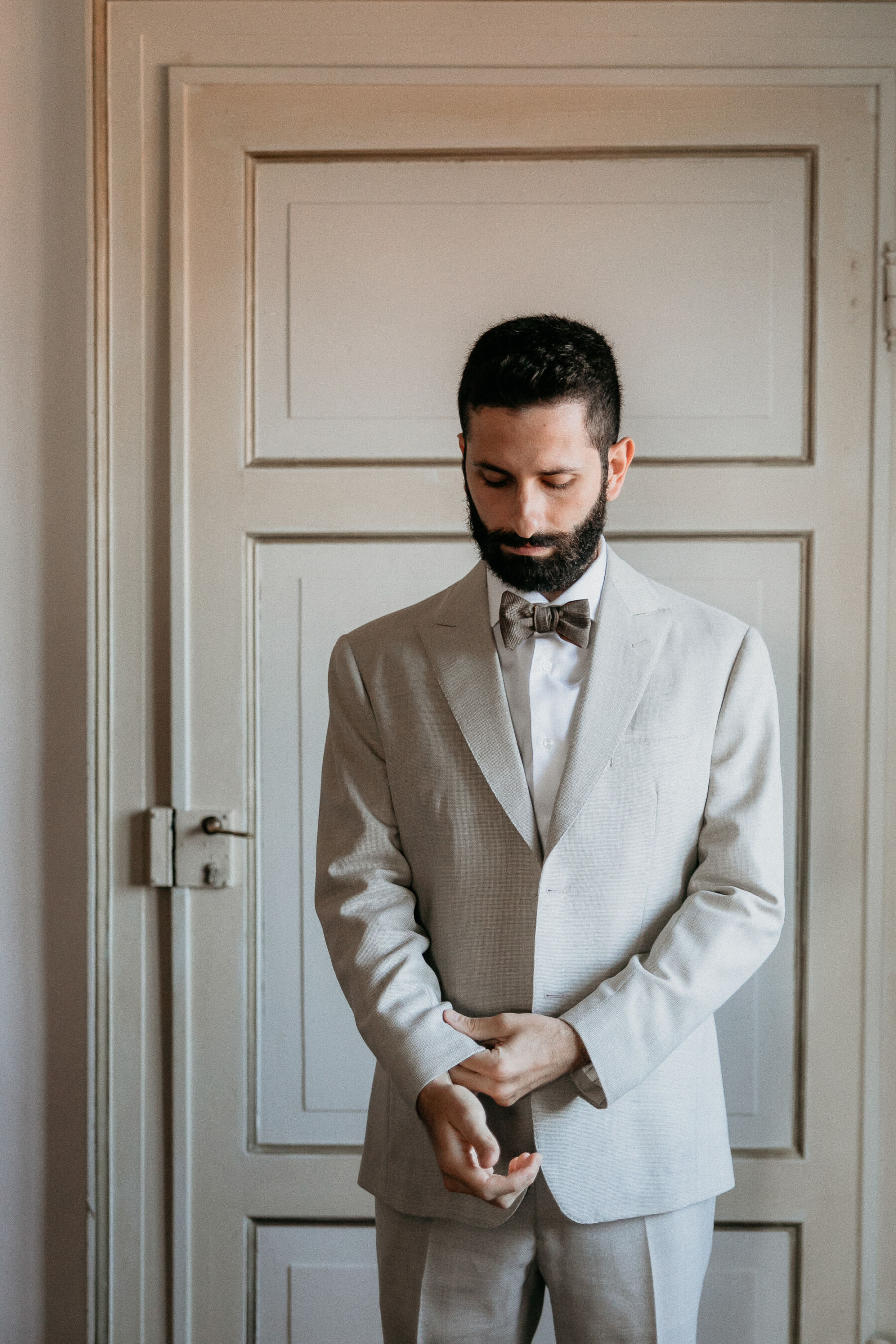 Italian groom in pale grey suit and silk bow tie.