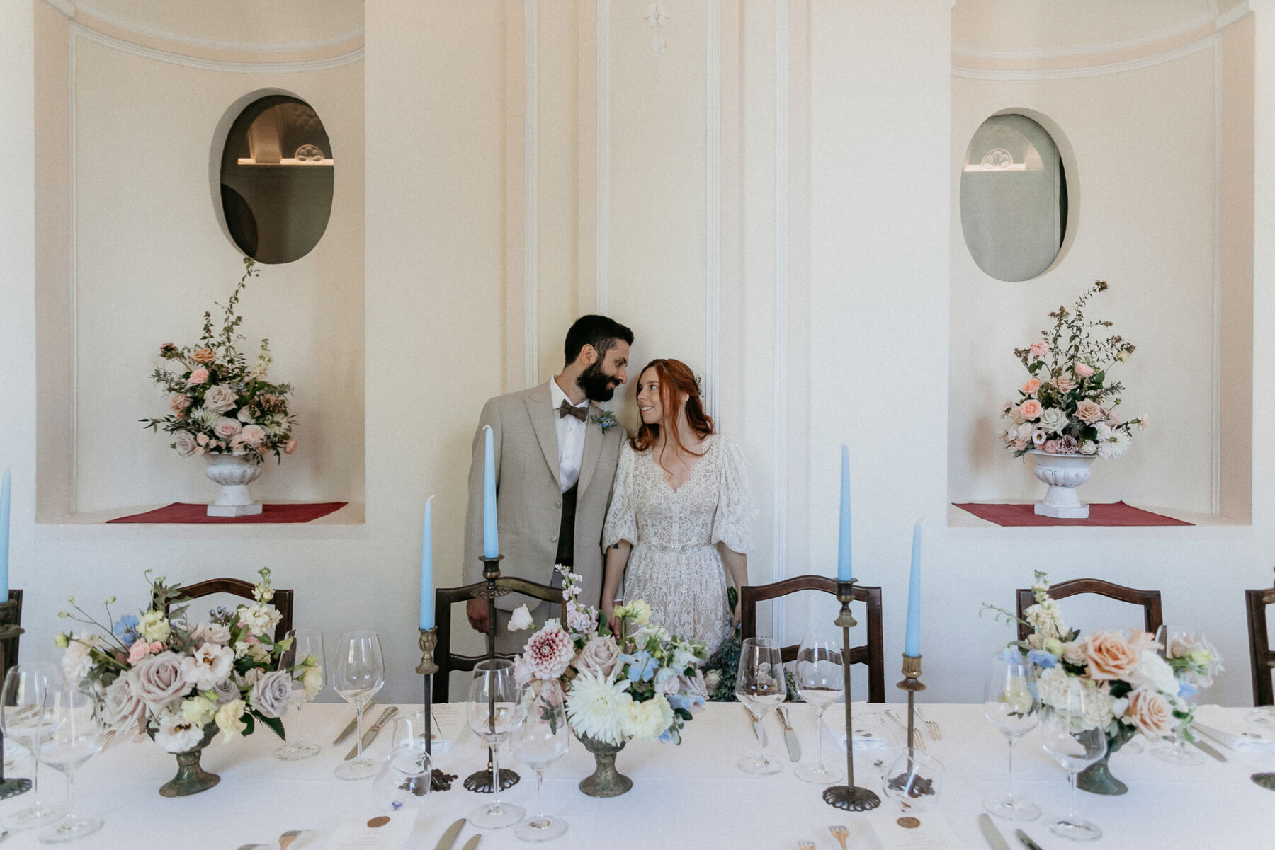 Katya Katya London for an Italian Wedding Inspired by Pre-Raphaelite Art 32 Romantic cream, peach and pale pastel wedding flowers with tall blue taper candles. Italian wedding.