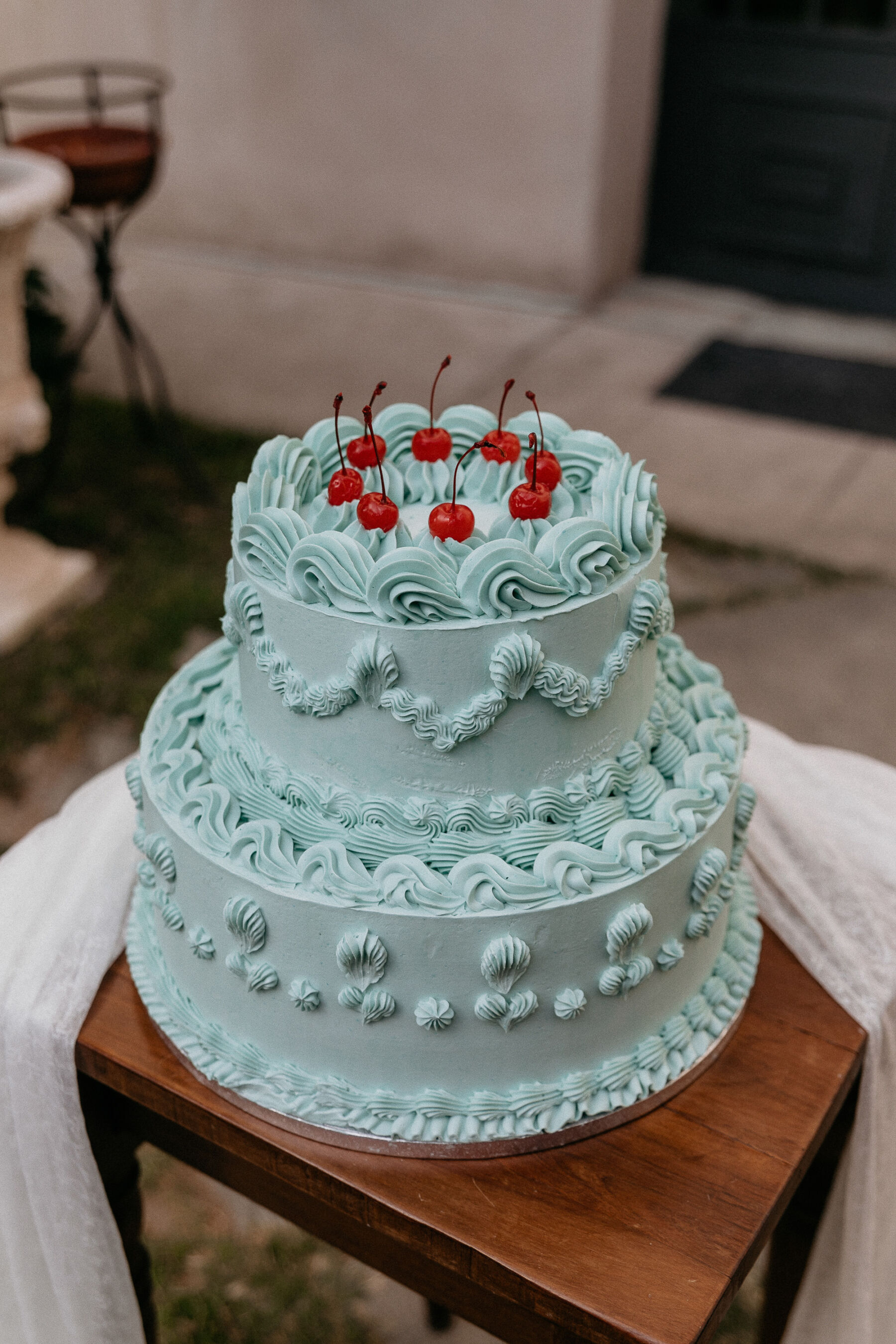 Katya Katya London for an Italian Wedding Inspired by Pre-Raphaelite Art 36 Fancy blue iced wedding cake topped with cherries.