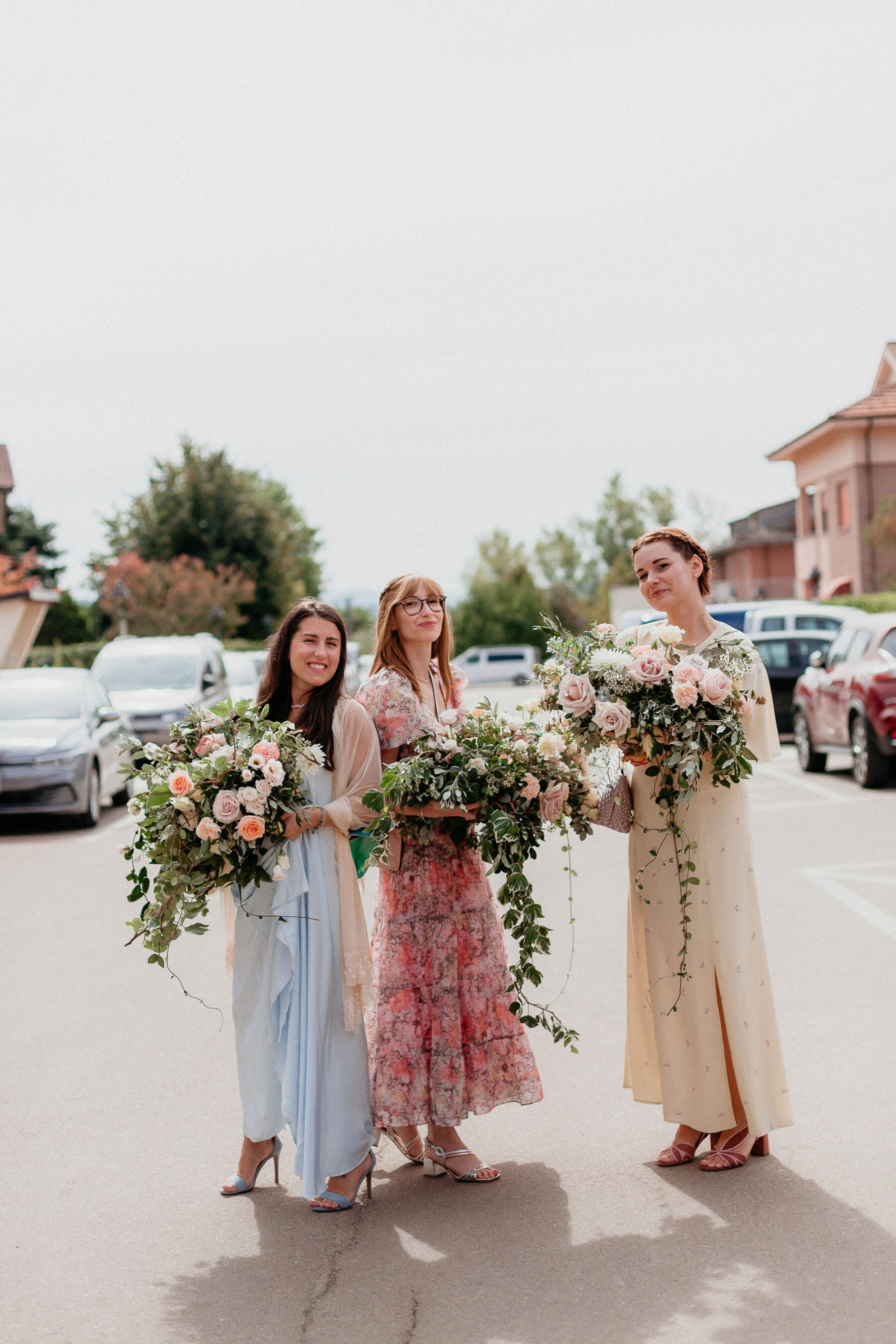 Bridesmaids holding large wedding bouquets.