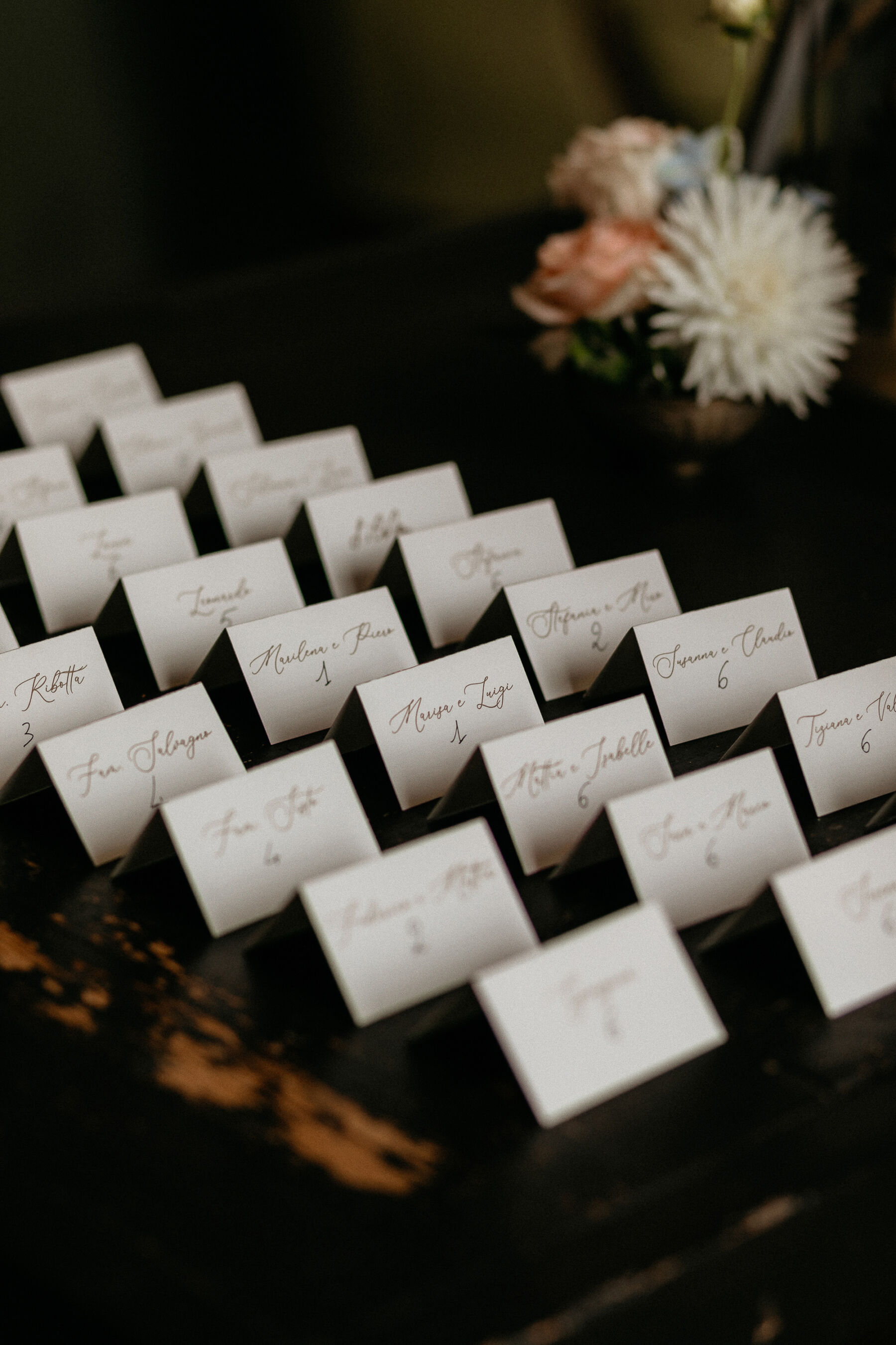 Handwritten wedding place cards lined up in a row.