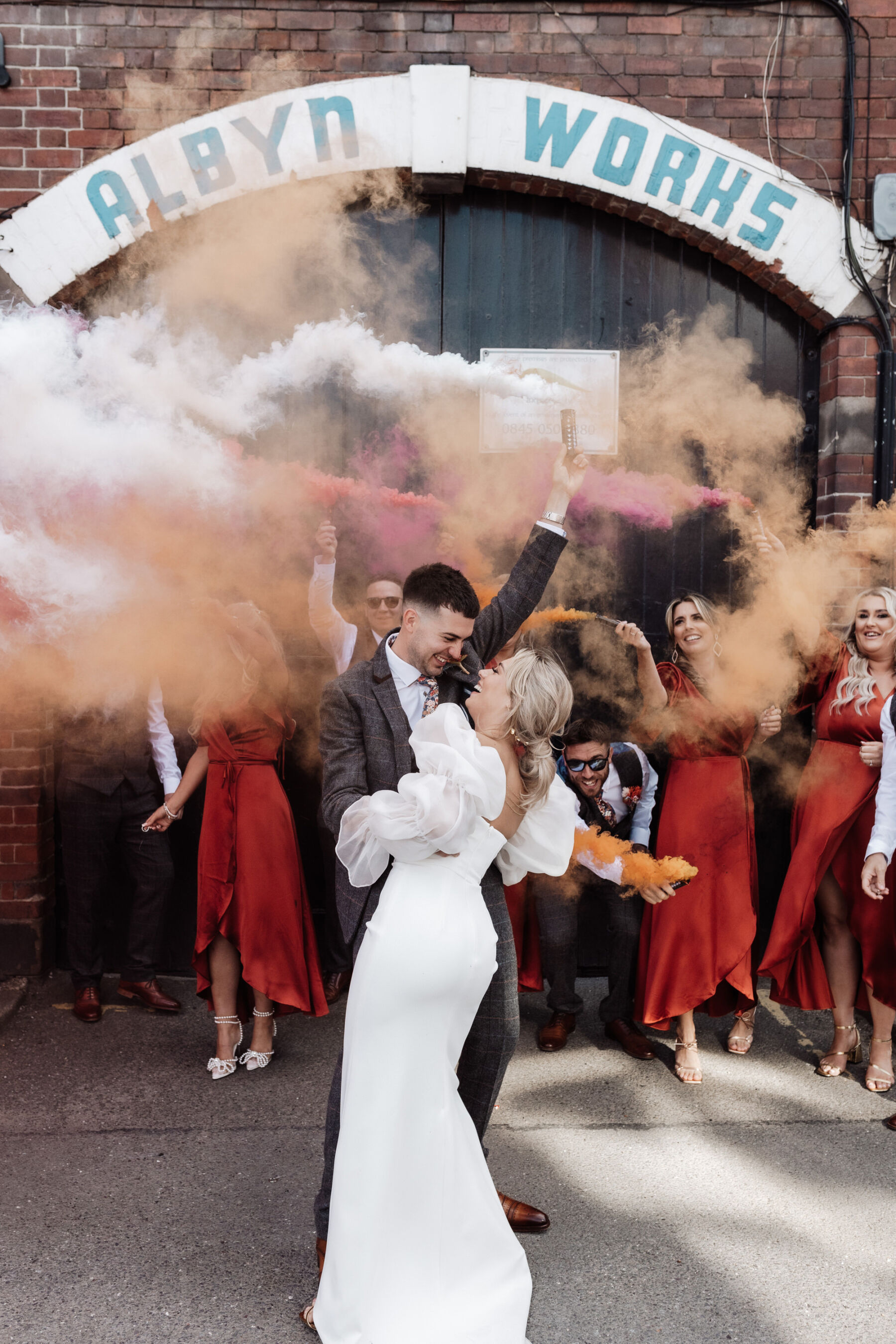 Nat, in Charlie Brear & Jesus Peiro for her Sheffield Botanical Gardens & Warehouse Party Wedding 36 Wedding smoke bombs at Peddler Warehouse wedding venue in Sheffield. Alexandria French Photography.