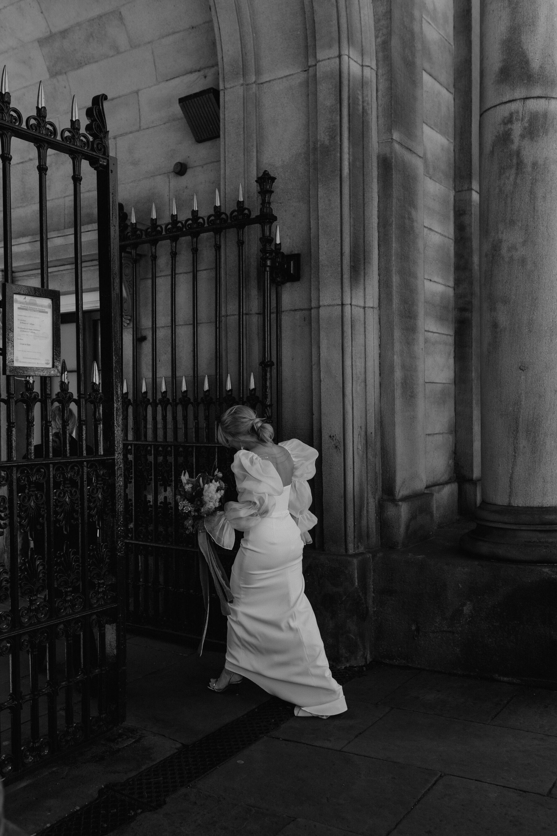 Black and white shot of modern bride walking through the city centre. Alexandria French Photography.