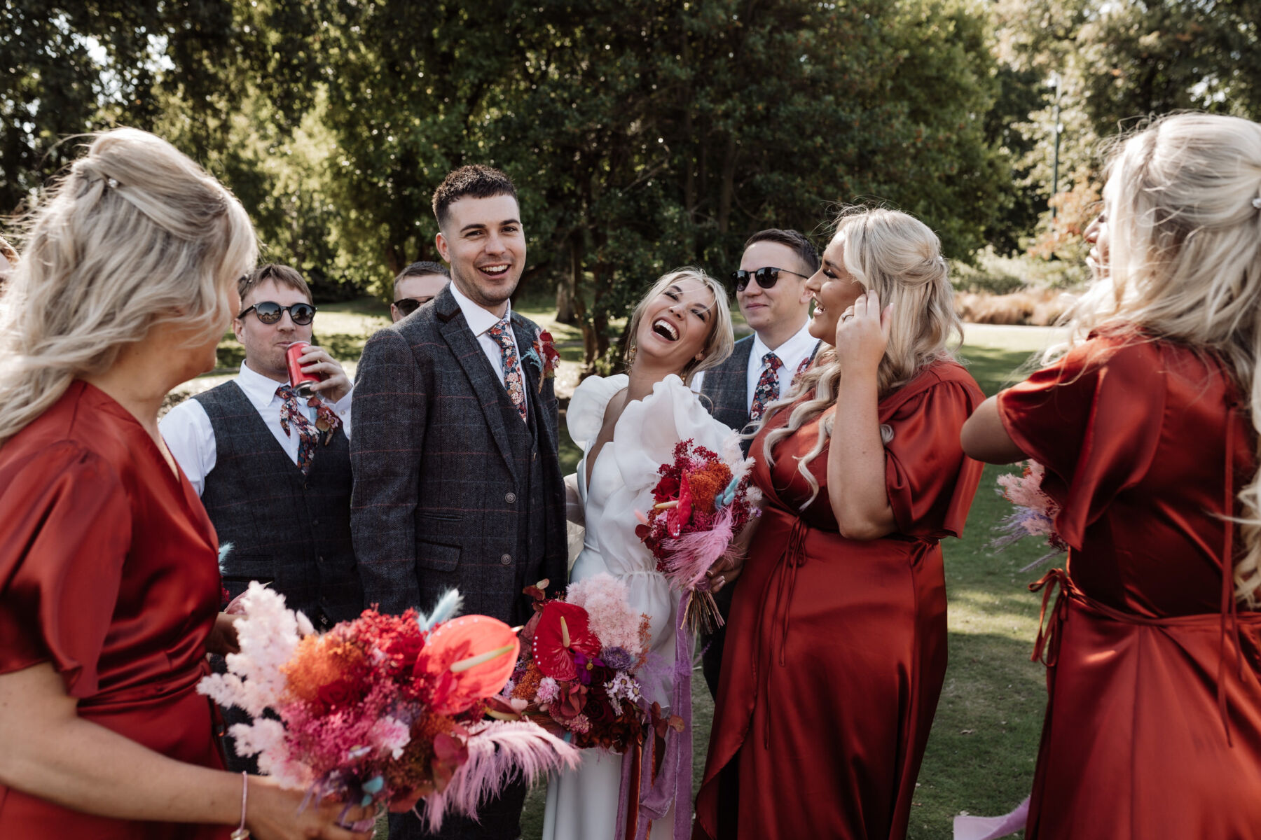 Bridesmaids in burnt orange and happy bride in detachable sleeves by Jesus Peiro and dress by Charlie Brear