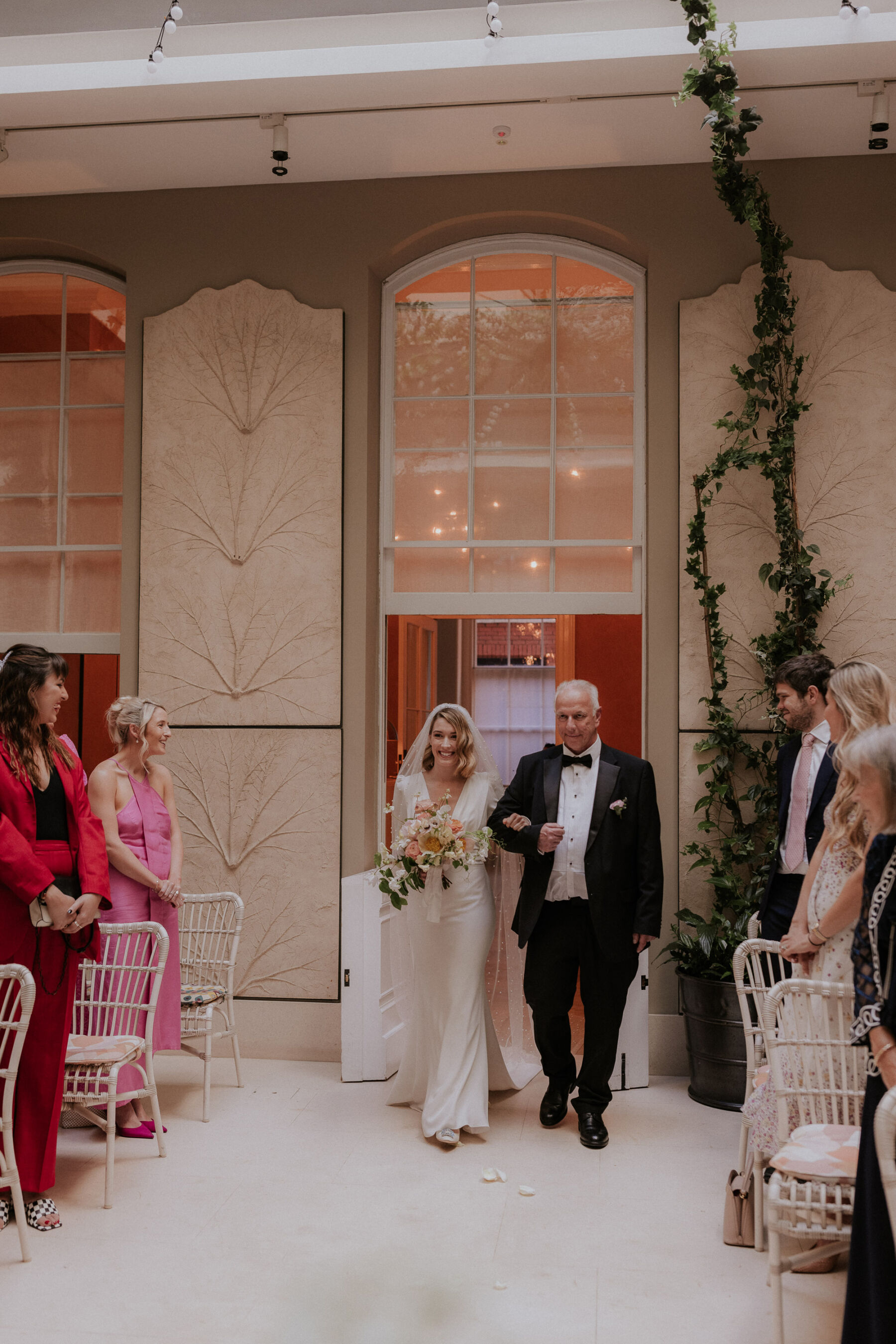 Ella in Pronovias for her Elegant Wedding at Spring Restaurant, London 16 Bride arm in arm with her father (in black tie) arriving at the ceremony at Spring Restaurant wedding venue. Maja Tsolo Photography.