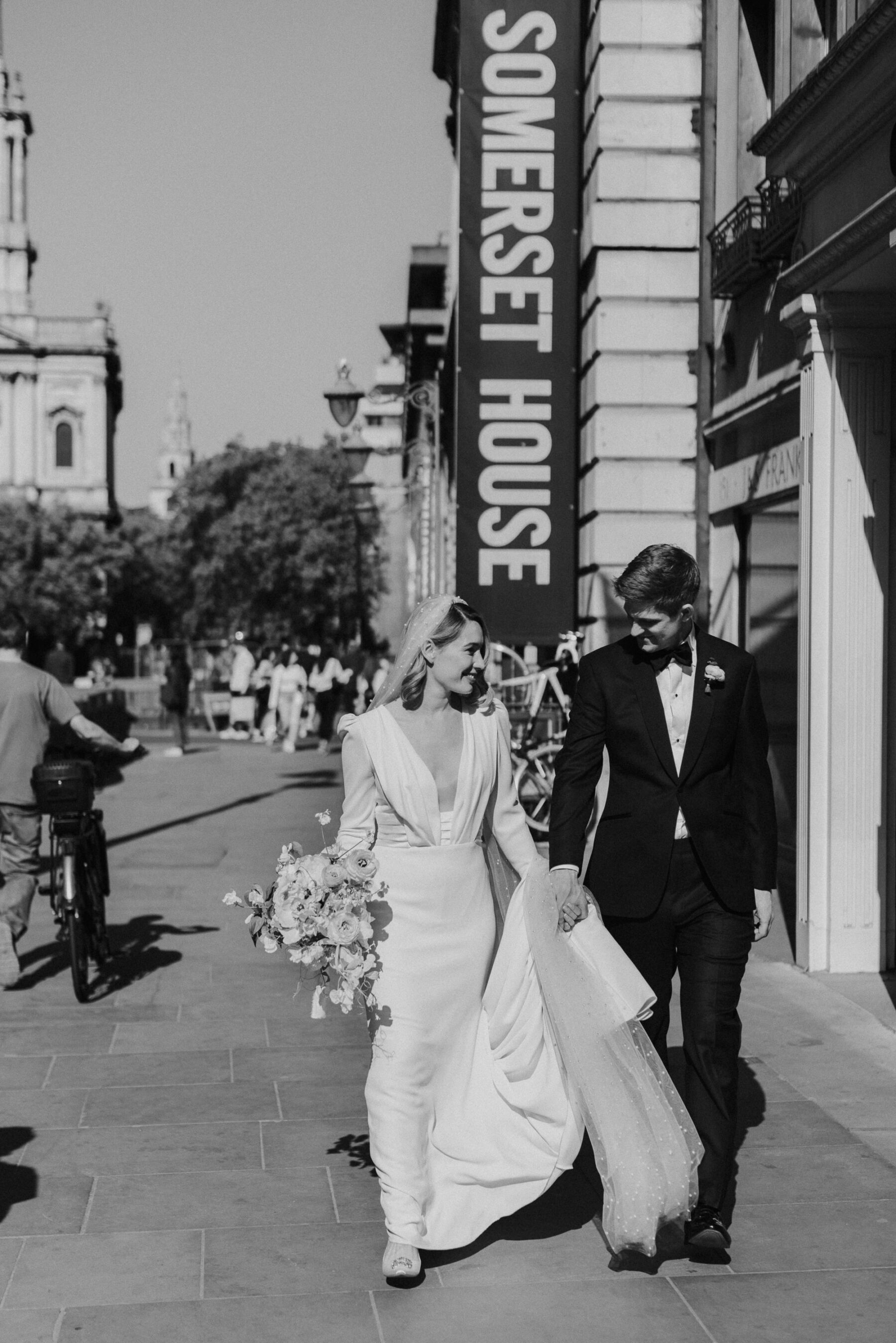 Black and white image of modern bride and groom walking the streets of London near Somerset House.  Maja Tsolo Photography.