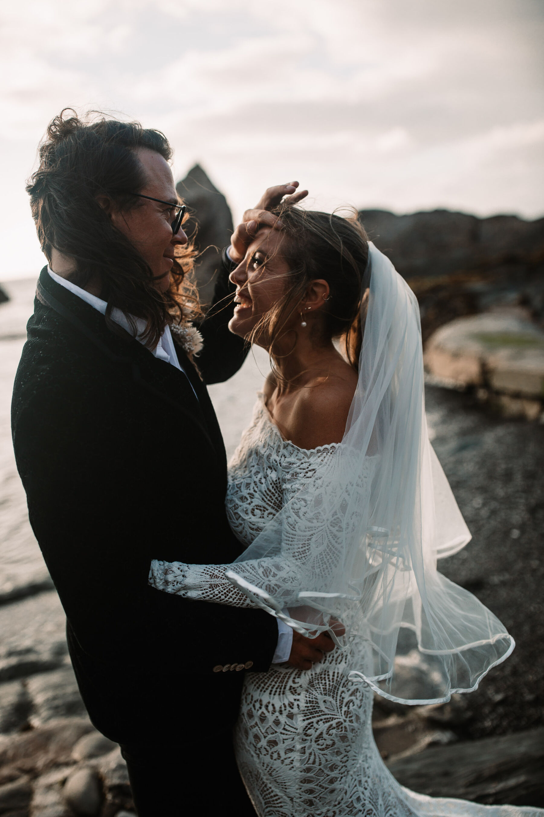 Bride and groom embracing at Tunnels Beaches in Devon.