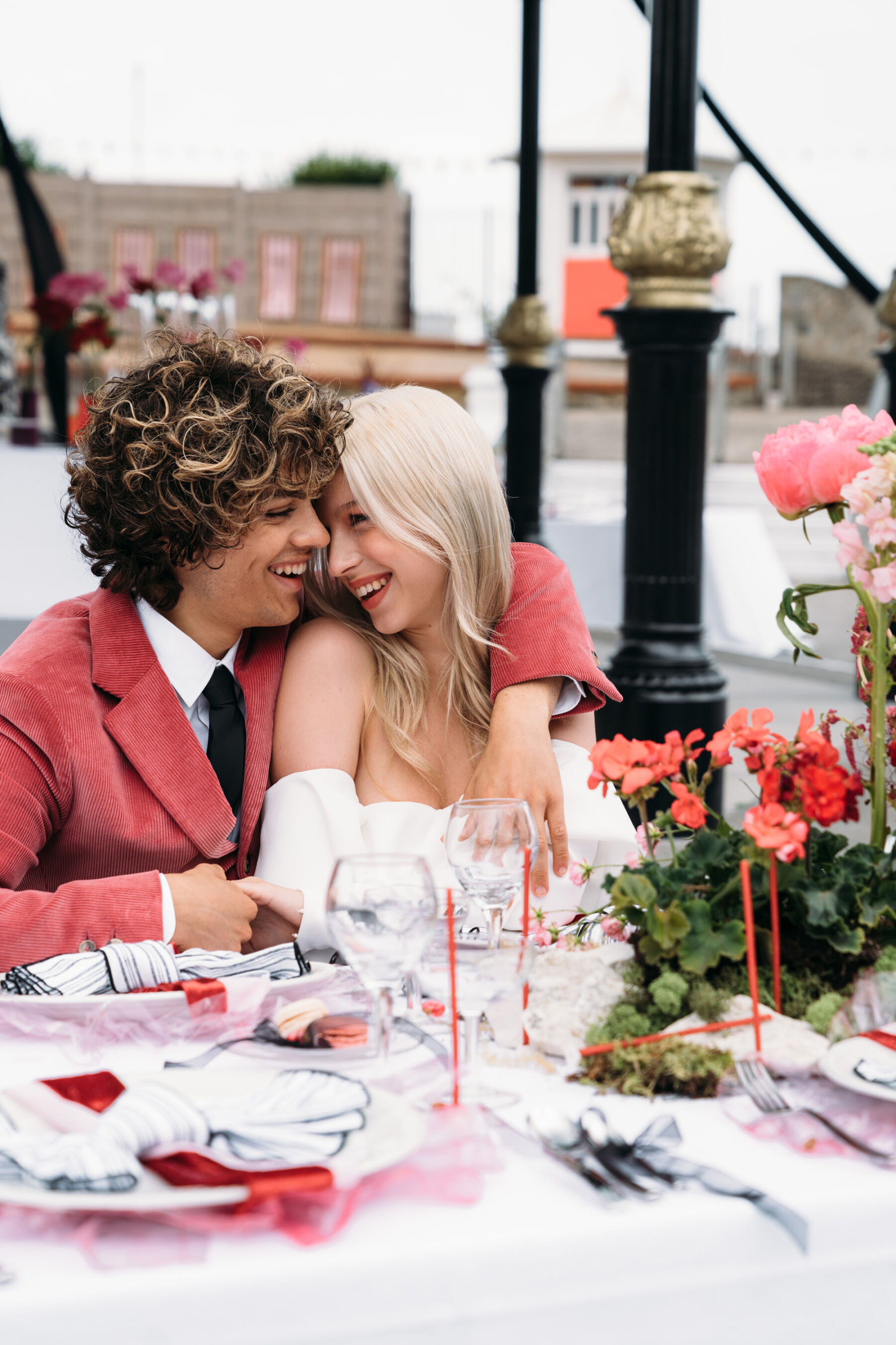 Groom in velvet red jacket embracing bride. Joanna Bongard Photography.