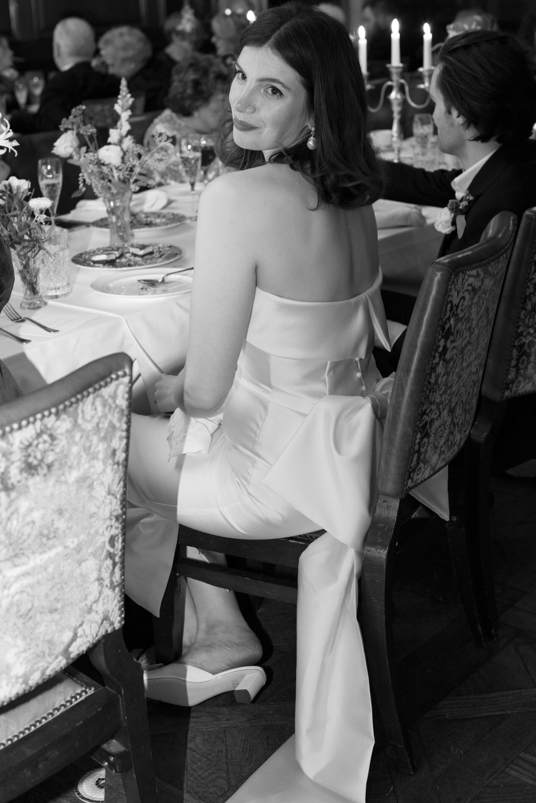 Bride seated at the reception in a stylish wedding dress by Jessica Bennett