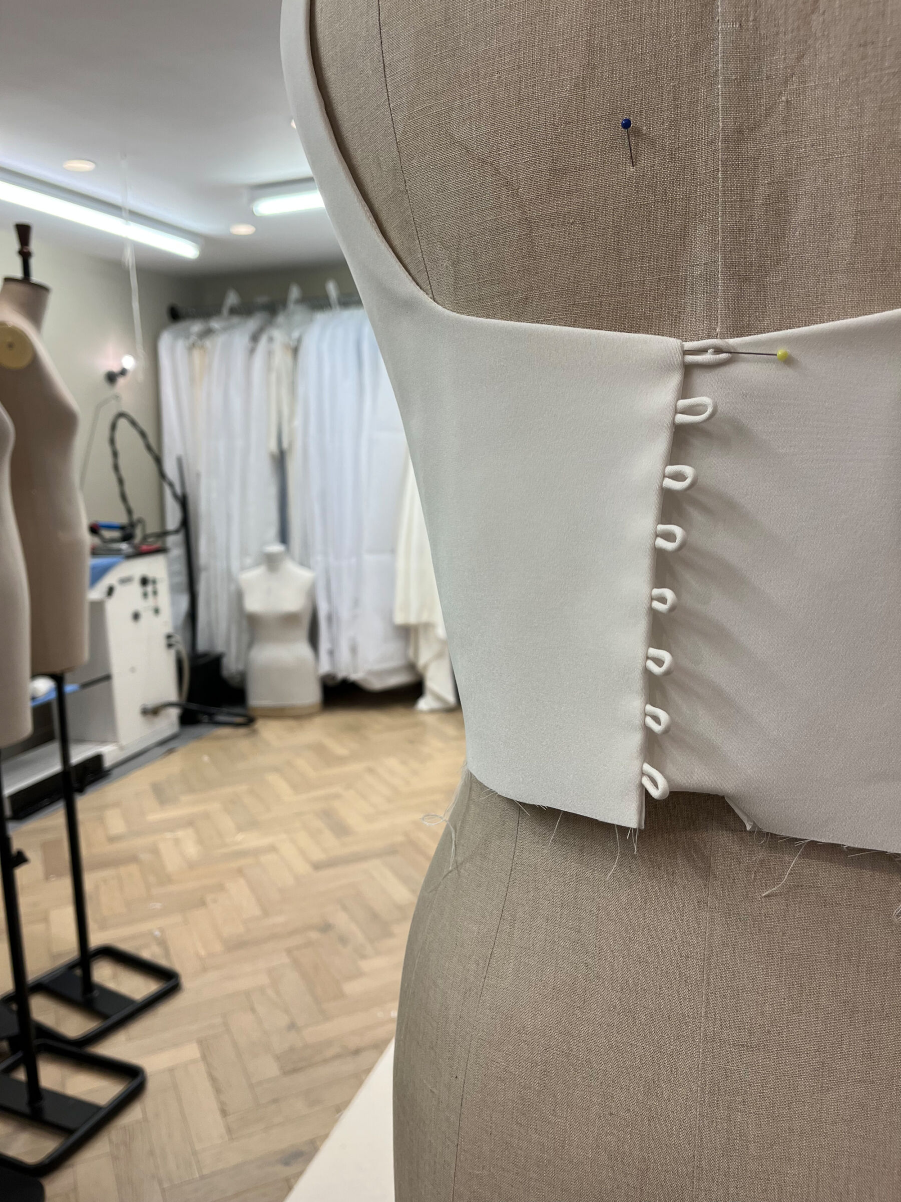The production room at Andrea Hawkes Bridal. Mannequin with wedding dress being made.
