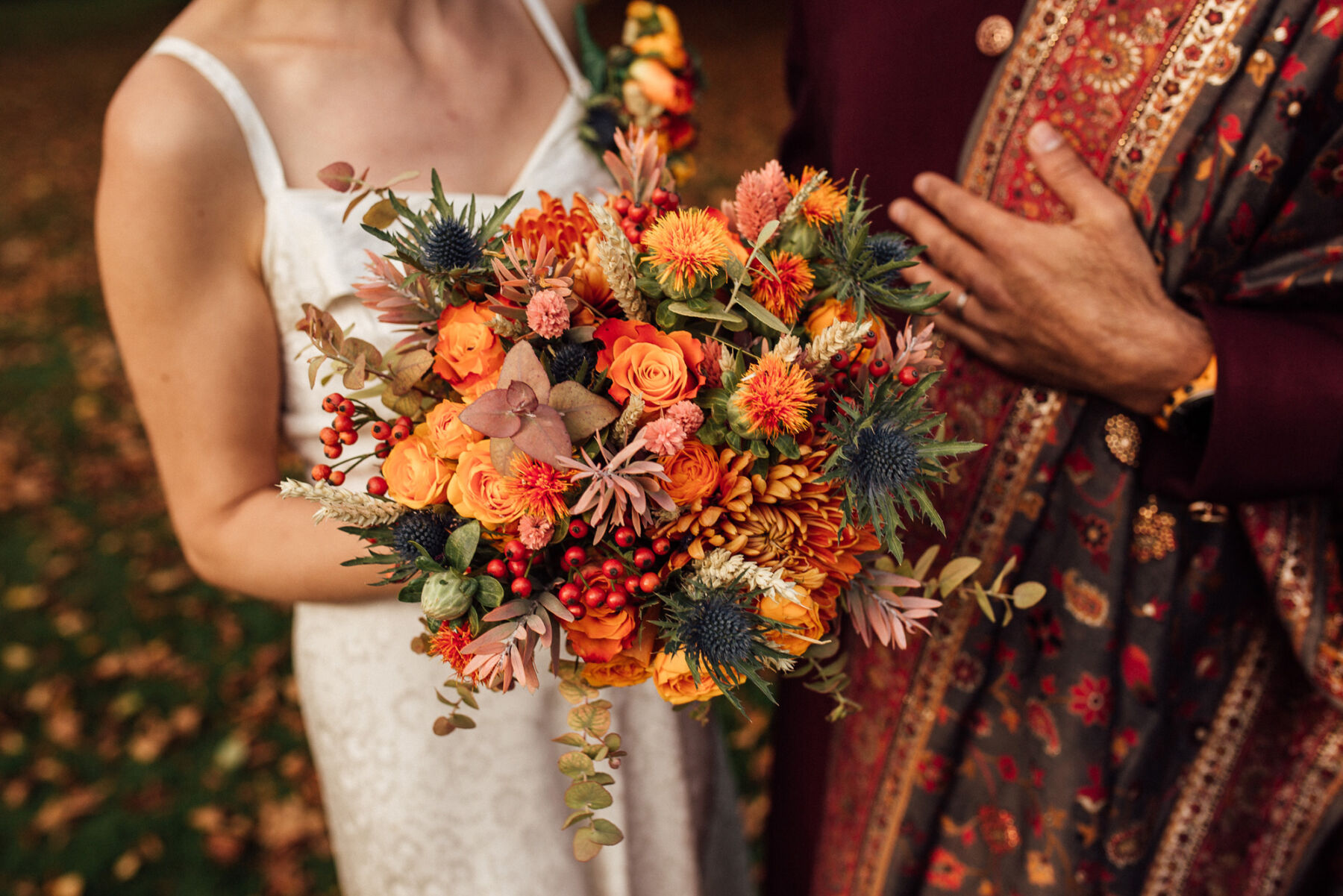 Bright, bold and colourful Autumn wedding bouquet in oranges and reds.