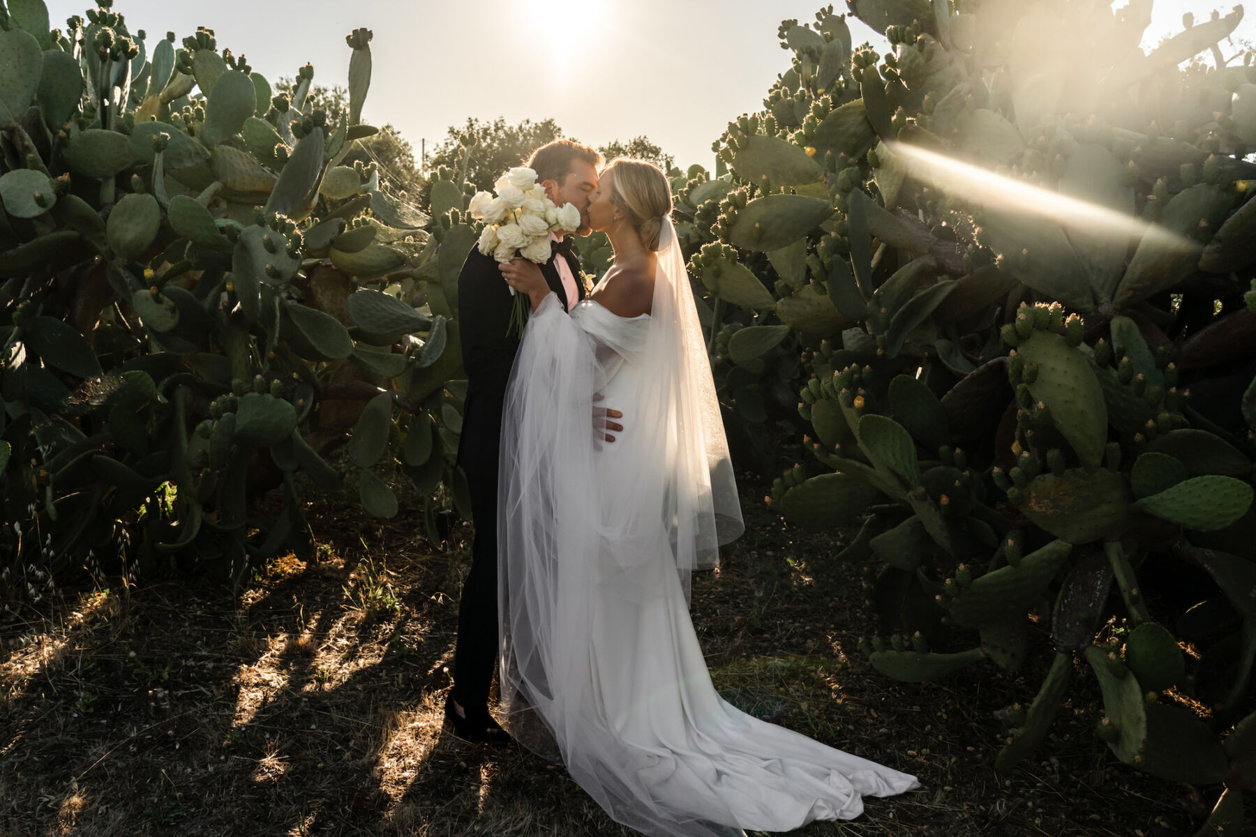 Bride and groom kissing at golden hour. Elisabetta White Italian wedding planner,