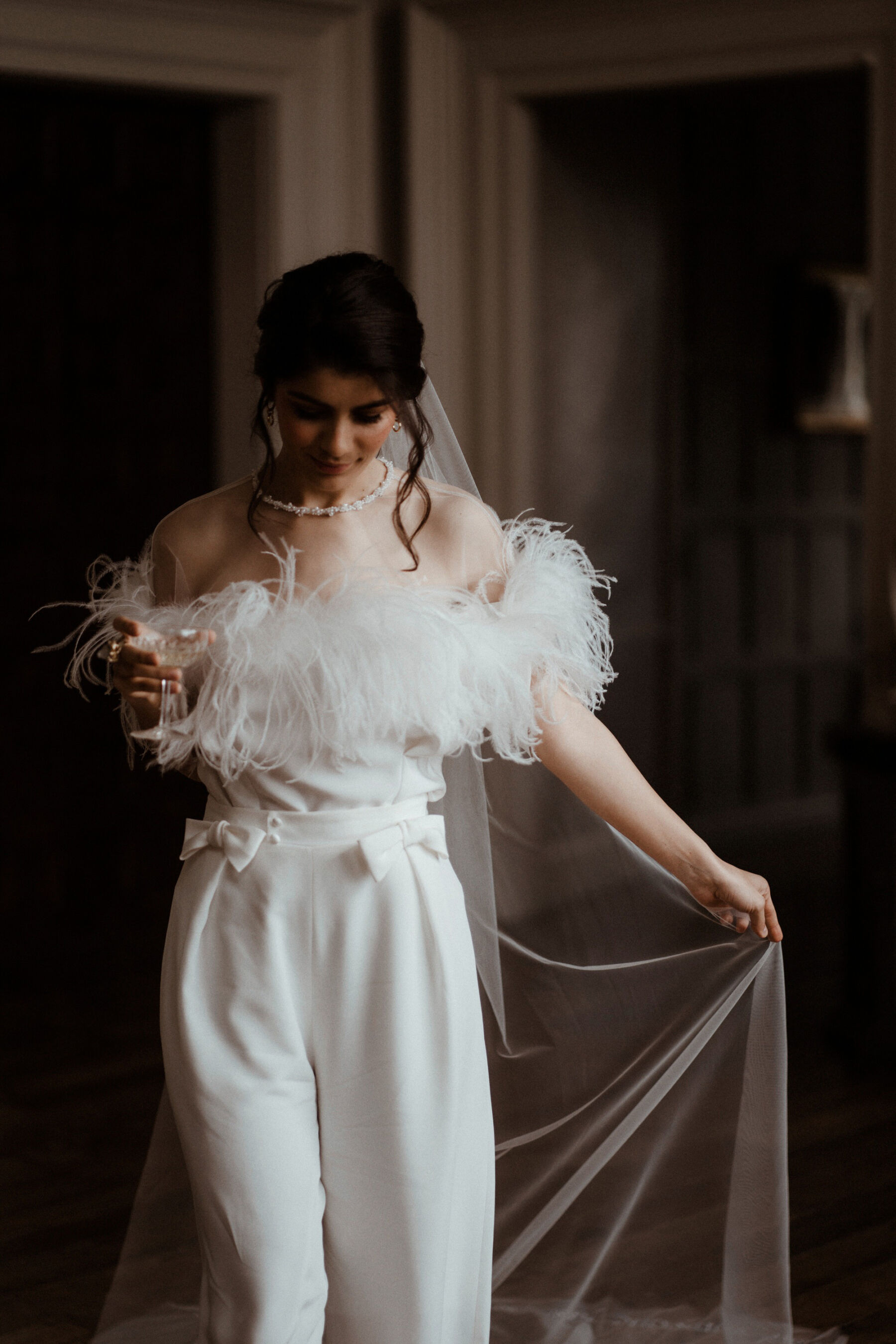 Bride wearing ostrich feather top and silk trousers by Wilden London, Embroidered wedding veil by Rebecca Anne Designs.