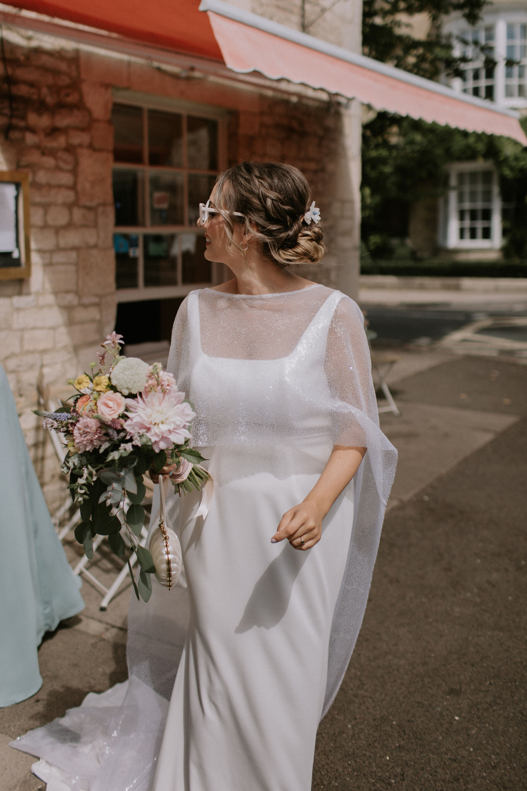 Beautiful summer wedding bouquet with dahlia and eucalyptus. Bride wears Charlie Brear summer dress and sequin cape.