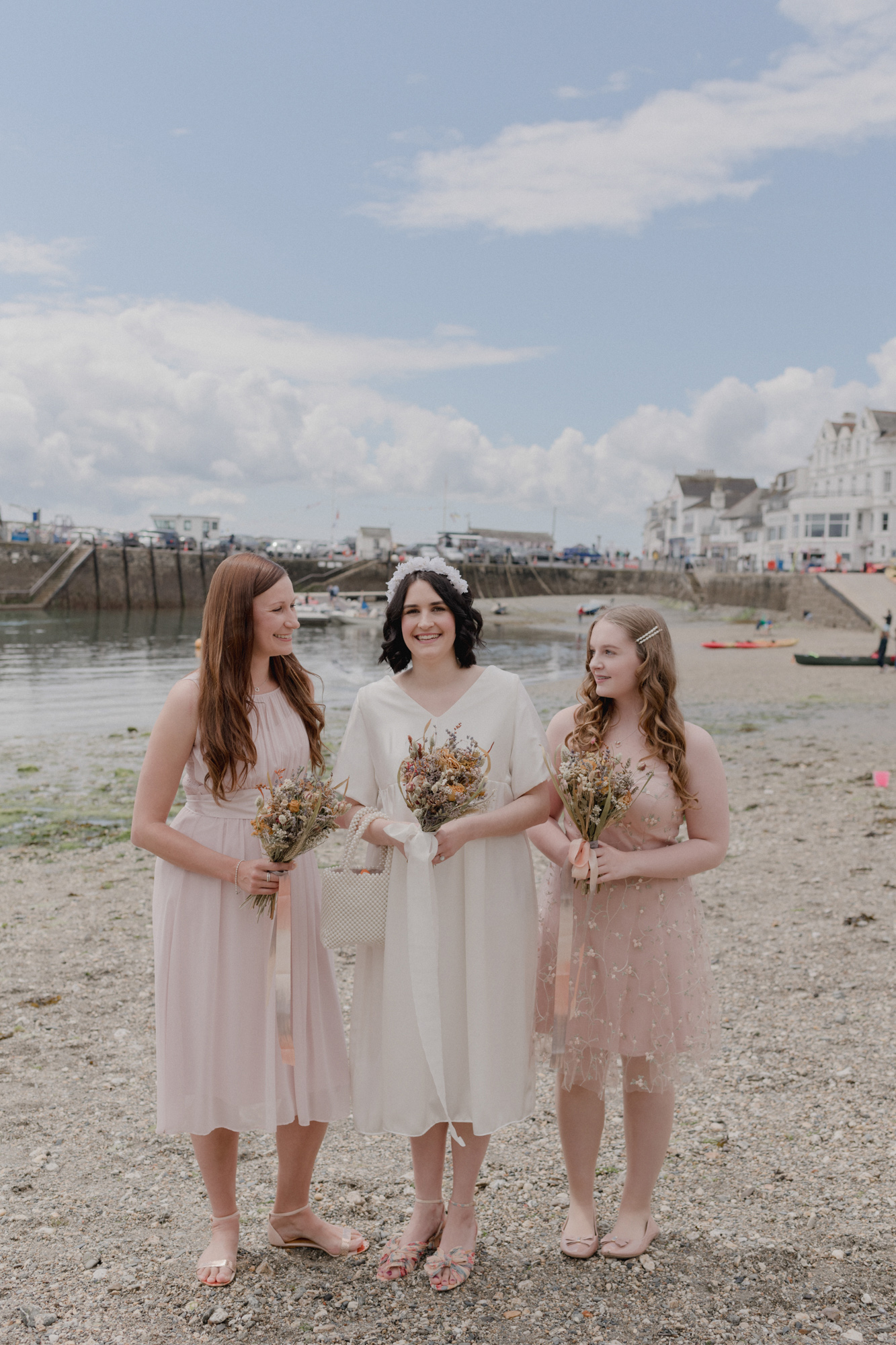 Bridesmaids in blush pink, bride in mid length wedding dress and Loeffler Randall shoes.