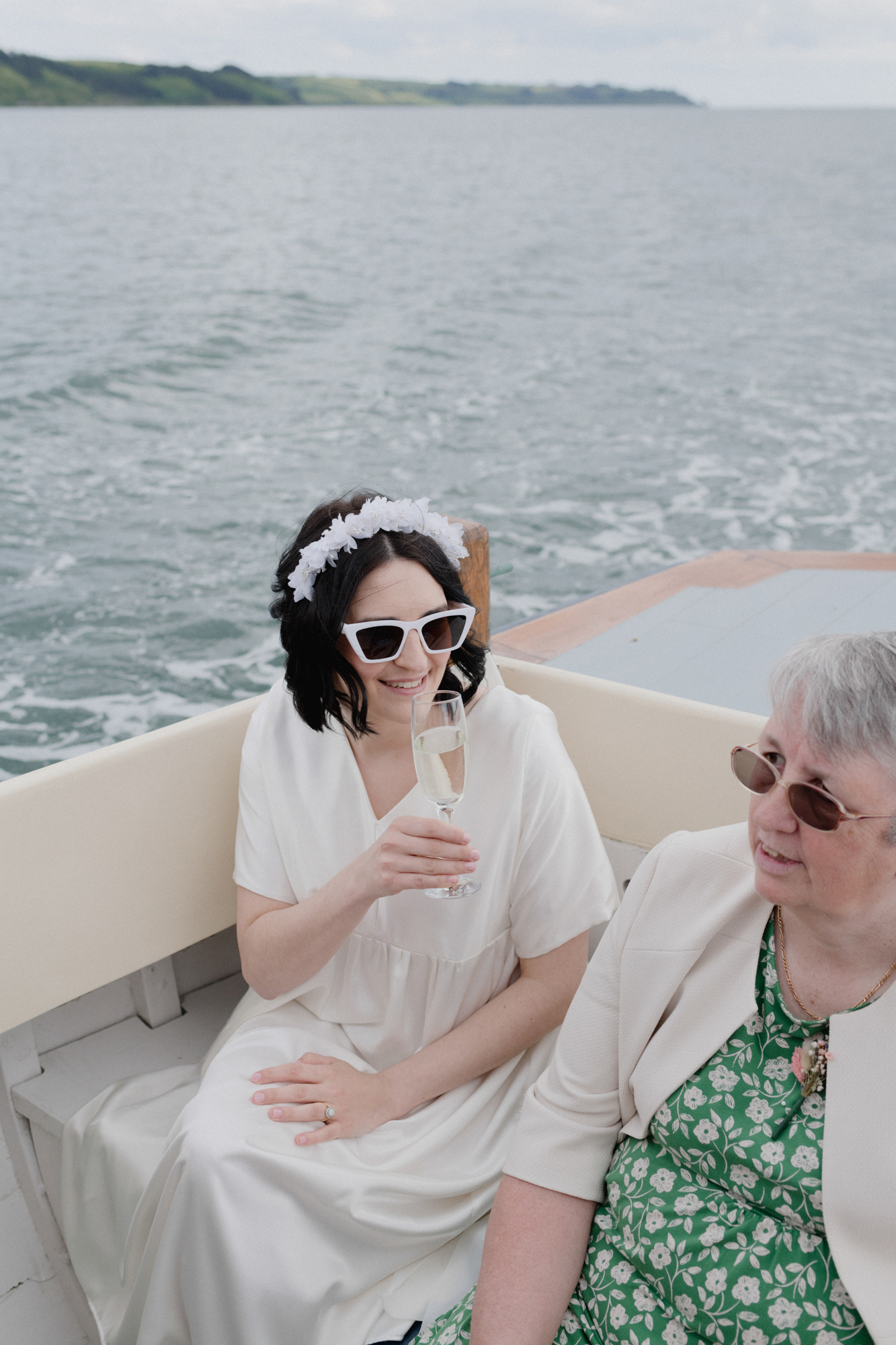 Bride in sunglasses on a boat with her mum