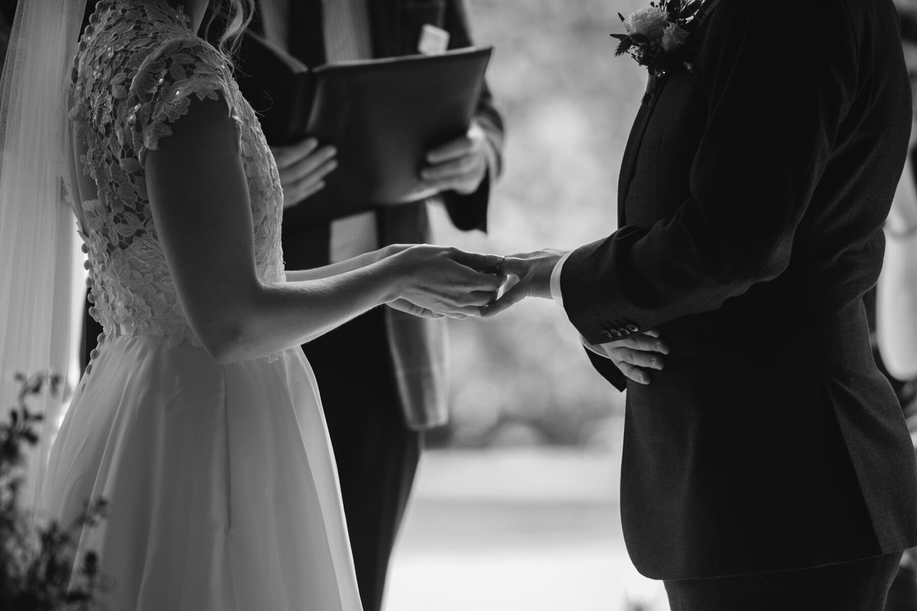 Bride and groom holding hands during their wedding ceremony.
