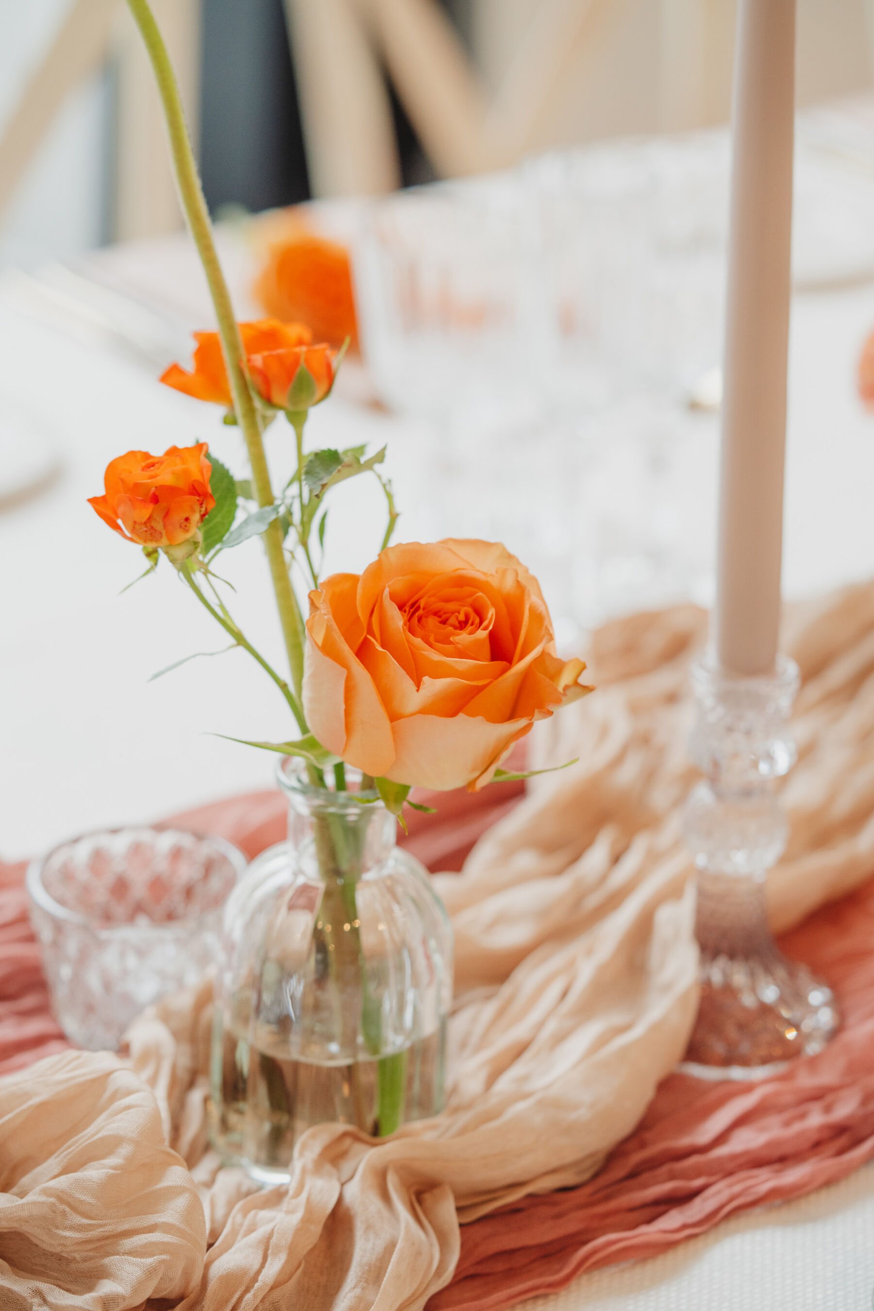 Delicate orange roses in bud vases