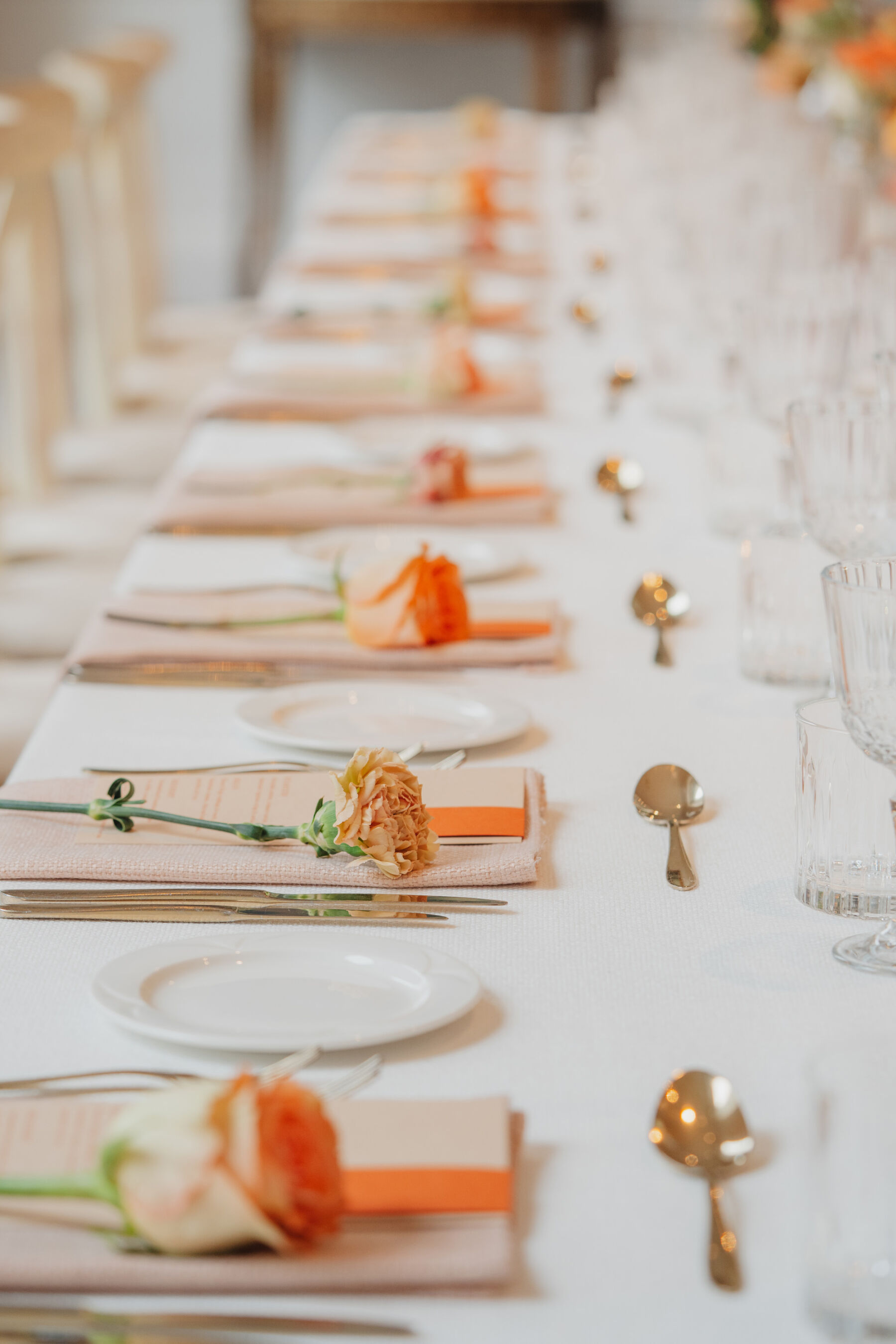 Single stem roses and gold cutlery.