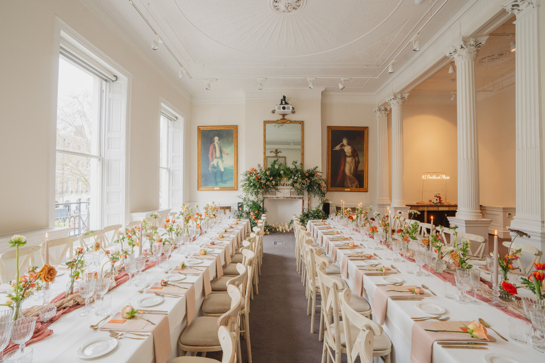 Light, bright and airy wedding reception room at 41 Portland Place London, decorated in burnt orange flowers and table decor.