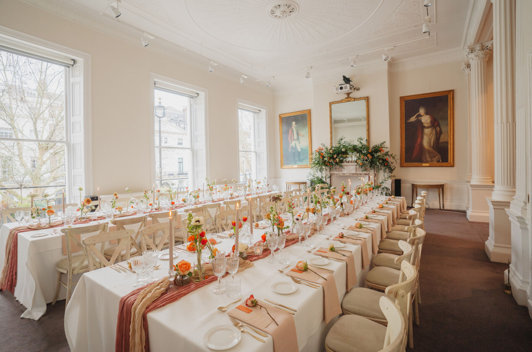 Light, bright and airy wedding reception room at 41 Portland Place London, decorated in burnt orange flowers and table decor.