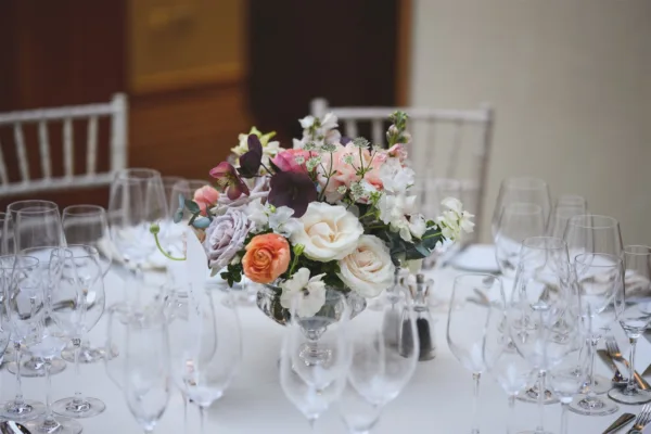 A table centrepiece for a wedding reception at 11 Cavendish Square, London. Full of roses, ranunculus & hellebore by Myrtle & Smith Flowers.