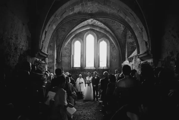 bride and grrom with window light, black and white at Hinton Priory, Bath.