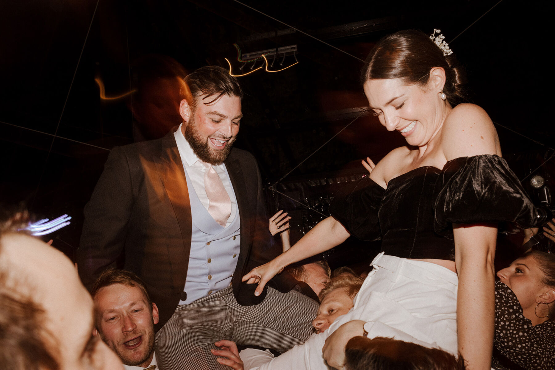 Bride and groom being lifted from the dancefloor