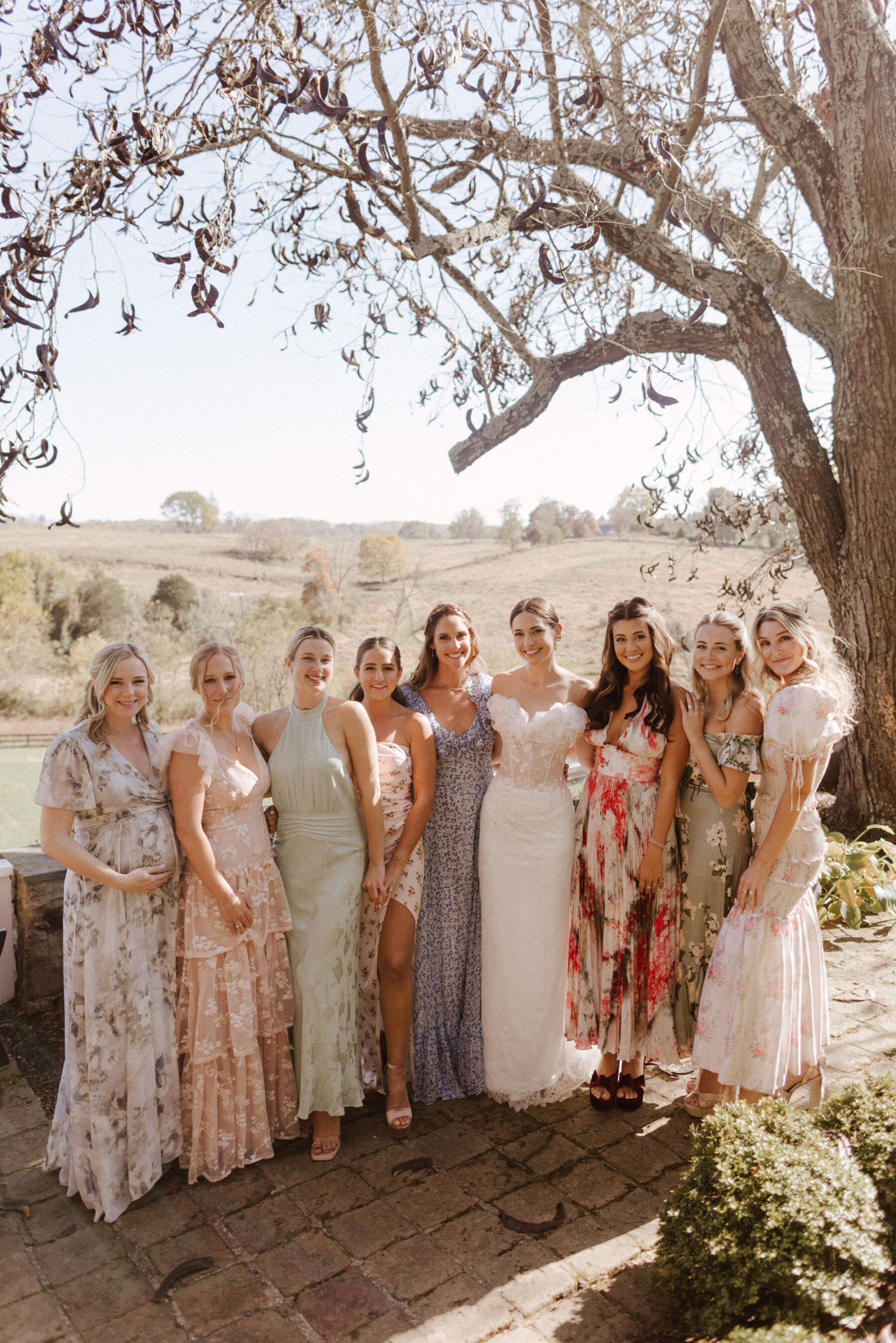 Bride wears Sally Bean Couture wedding dress standing with her besties in pretty mismatched bridesmaids dresses.